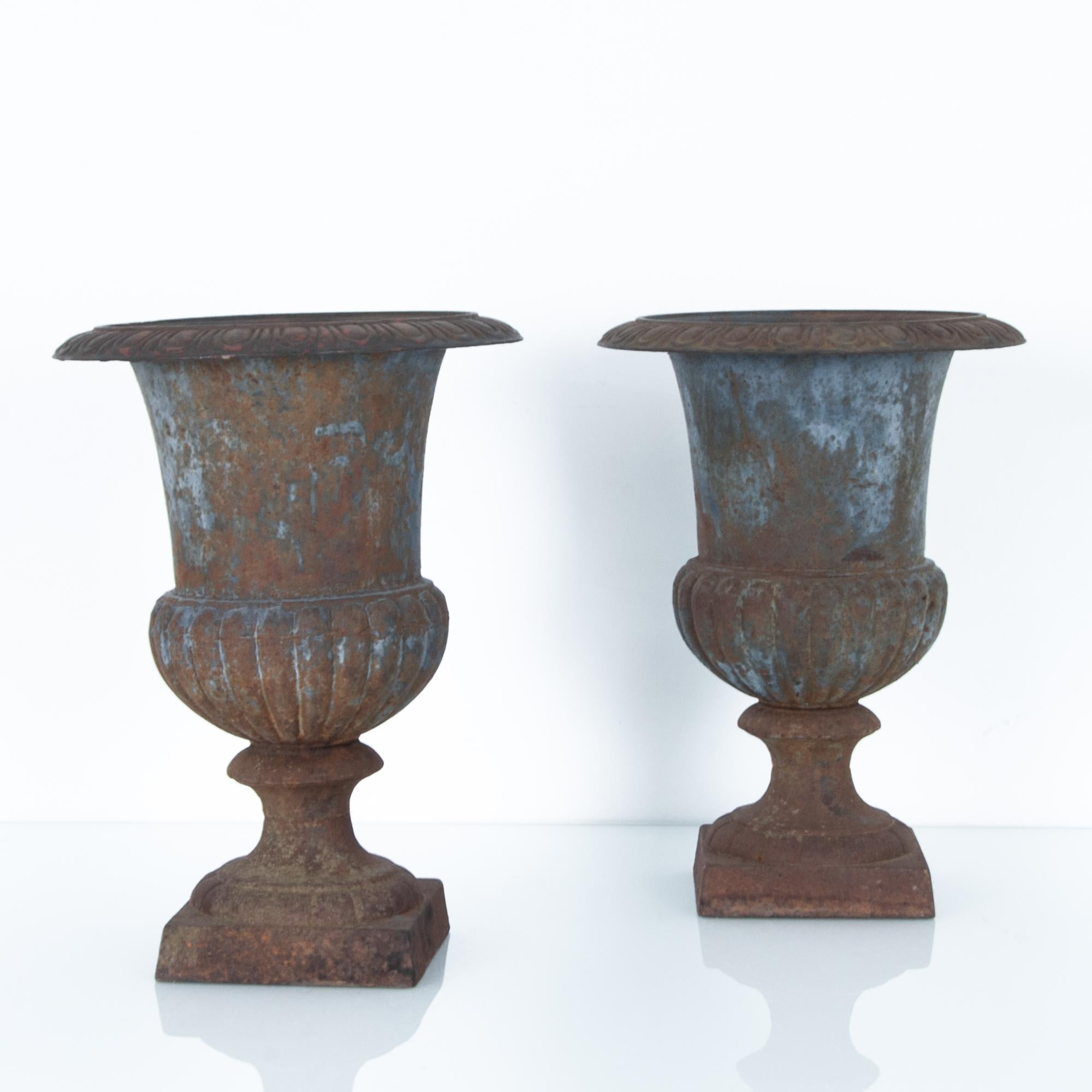 A pair of cast iron urns from France circa 1900. A venerated piece of garden furniture, the deep blue enamel is complimented by an oxidized patina. A green accent for a space needing texture.