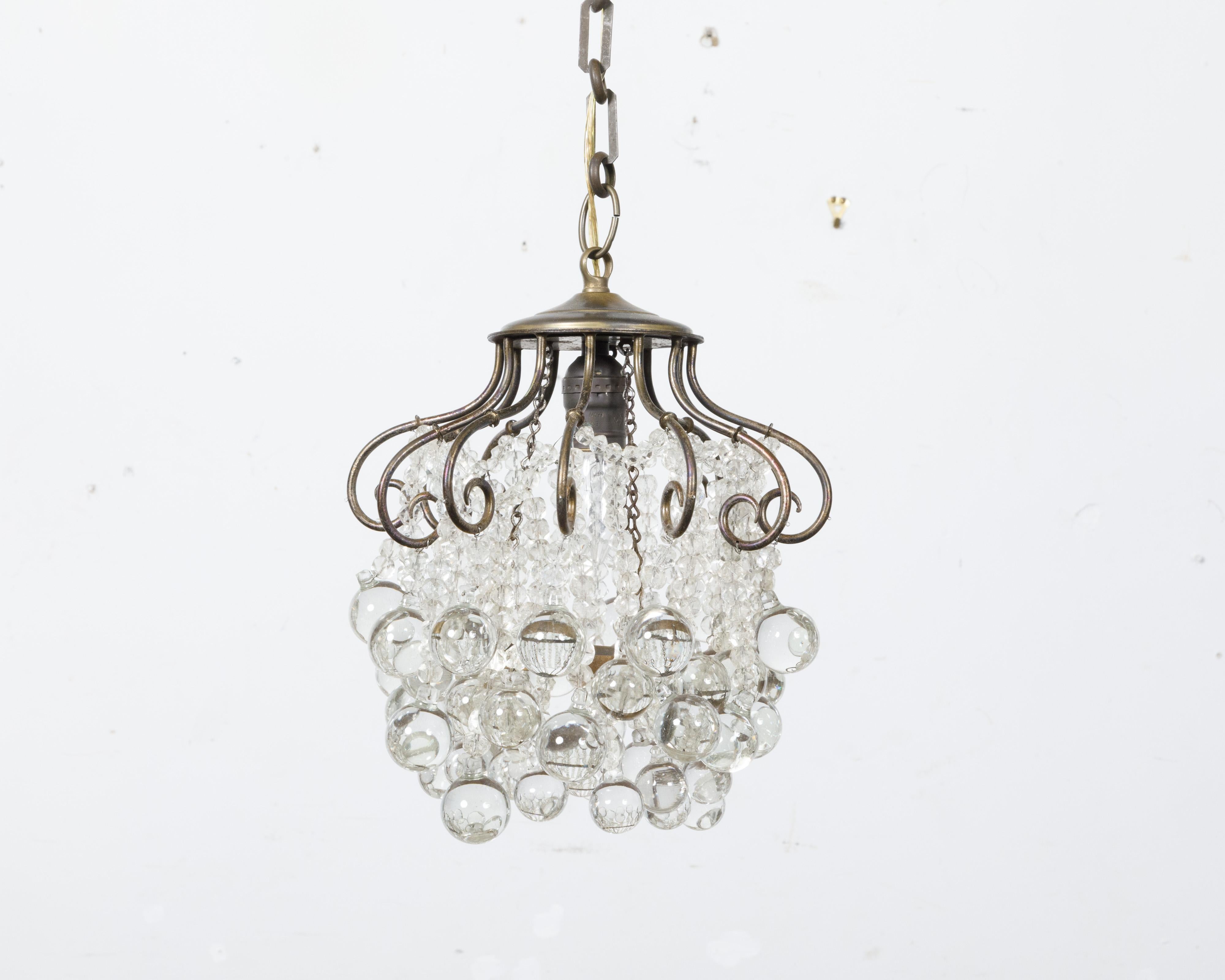 A French crystal chandelier from circa 1920 with cascading crystal curtain and scrolling effects, professionally rewired for the USA. This exquisite French crystal chandelier, dating back to circa 1920, is a stunning example of classic elegance and