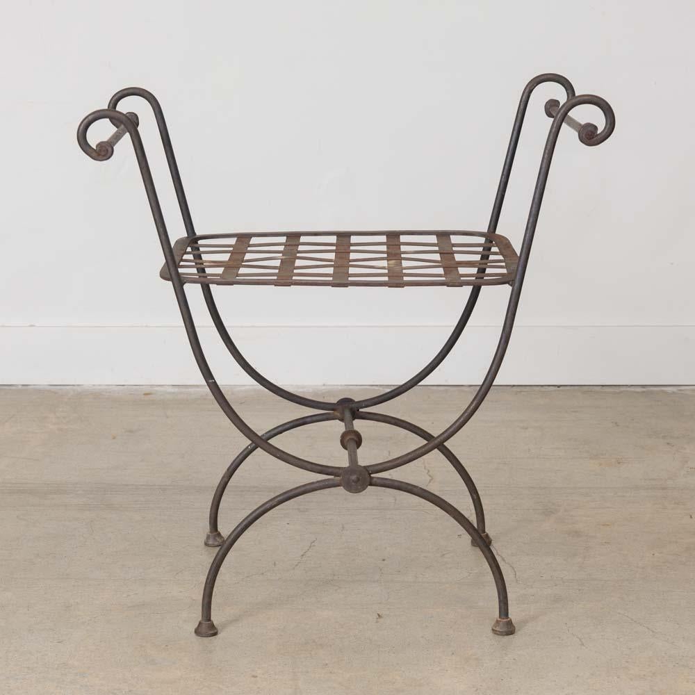 Sgabello in ferro Curule di grande effetto, proveniente dalla Francia, anni '20. Corpo sinuoso in ferro battuto con notevoli bracci alti e dettagli ad anello. La finitura originale mostra una buona età e patina. Perfetto per l'ingresso o per la