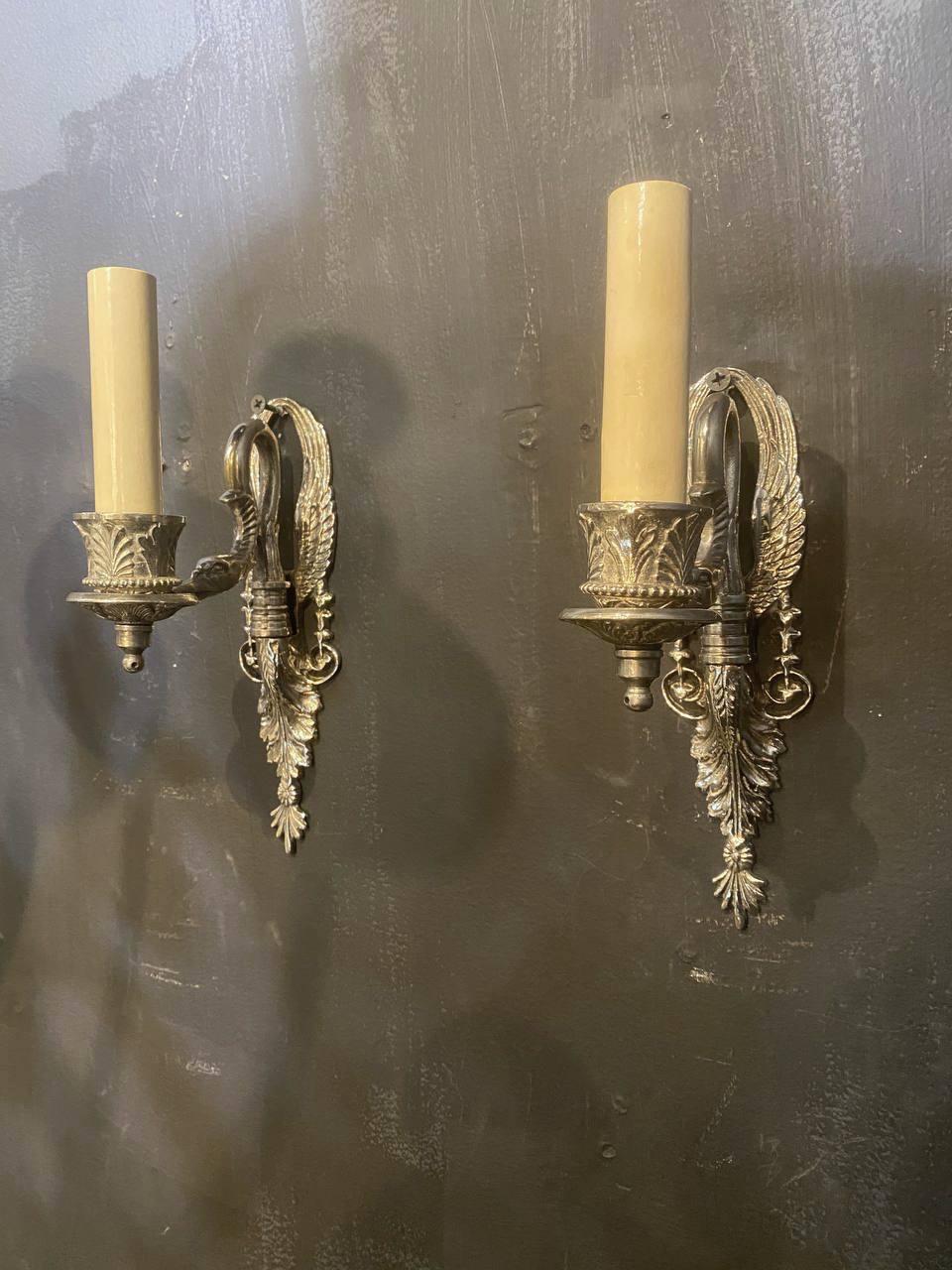 A pair of circa 1920’s French empire style one light silver plated sconces with swan head. Available in bronze