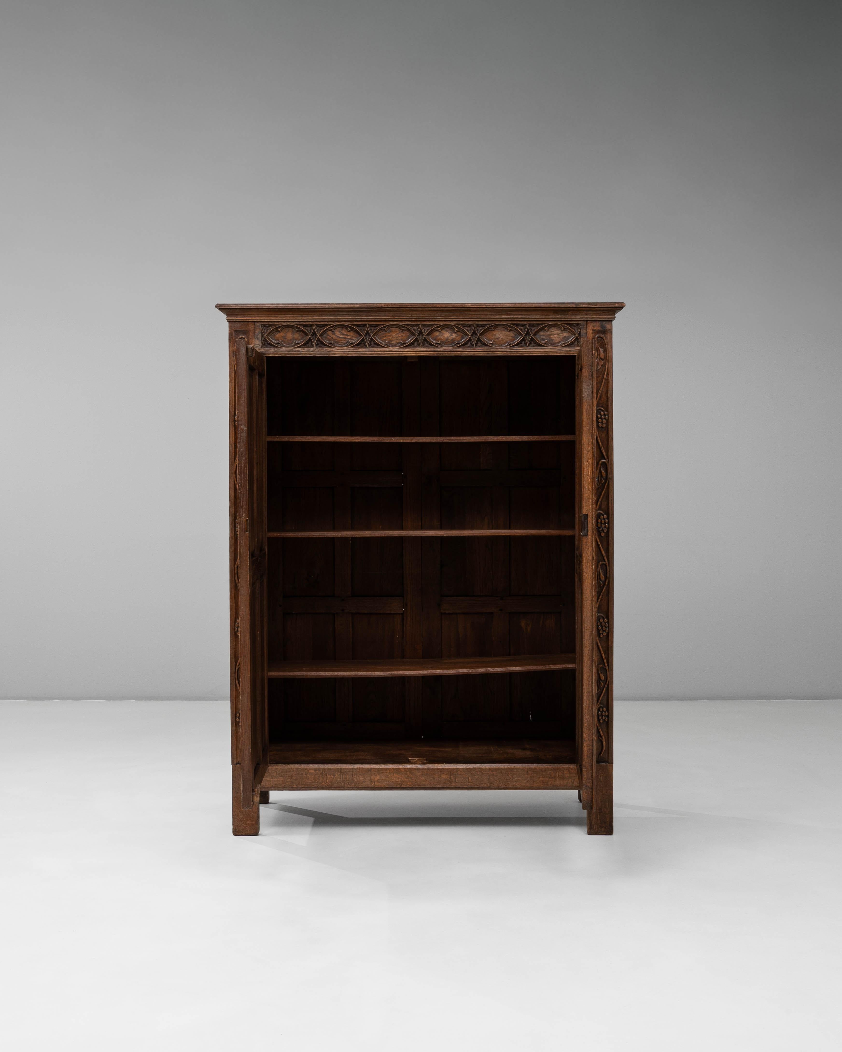 Questo mobile gotico francese in quercia degli anni '20 presenta un'eccezionale dimostrazione di artigianato d'epoca, definita dai suoi intricati intagli e dalla patina originale ricca di texture. La facciata presenta alti pannelli ad arco ispirati