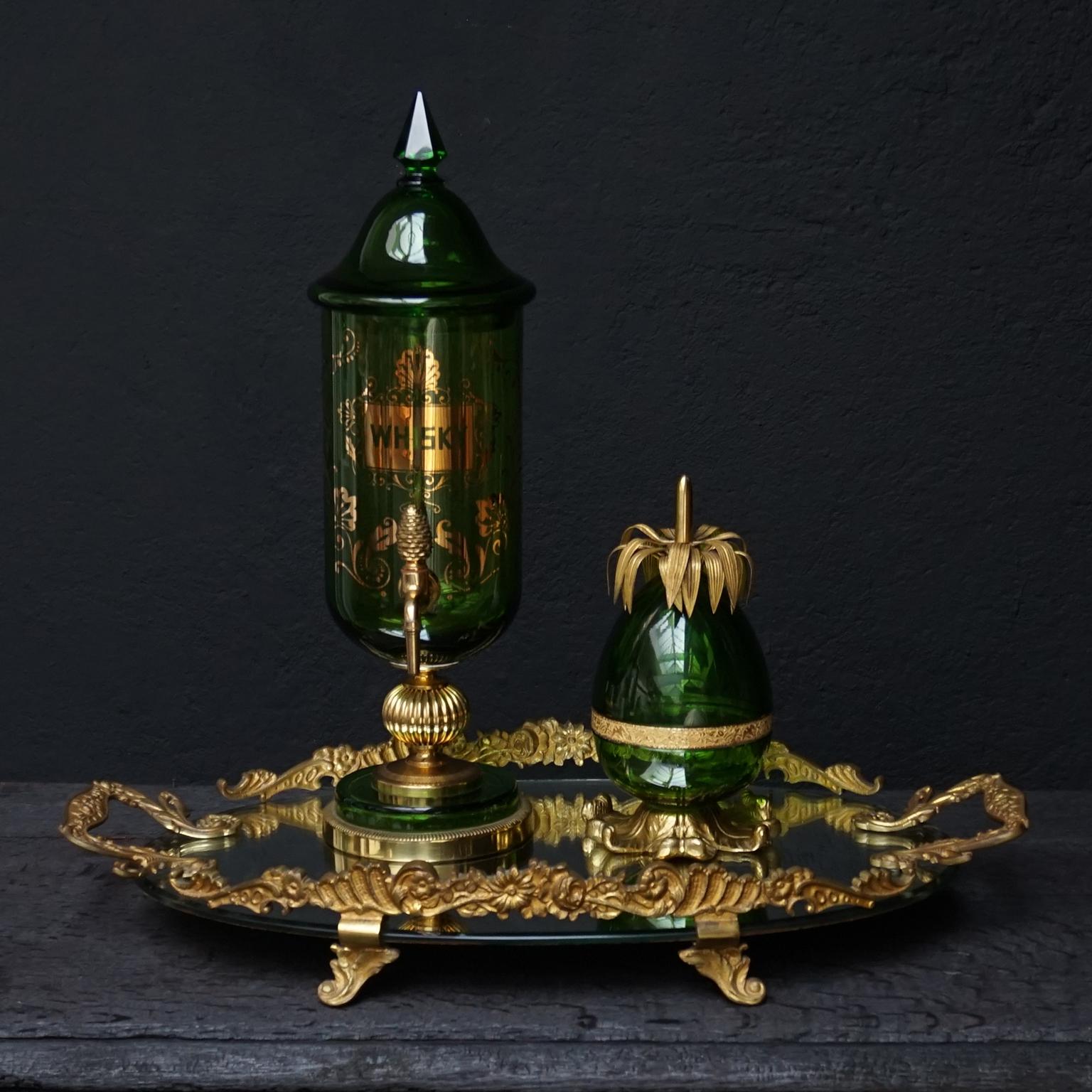 Antique French green glass and gilt bronze Hollywood Regency bar set on a mirror tray.
On the tray a pineapple lidded bowl and a whisky dispenser with tap. 

Very pretty heavy set with a pineapple shaped lidded green glass bowl with gilt bronze