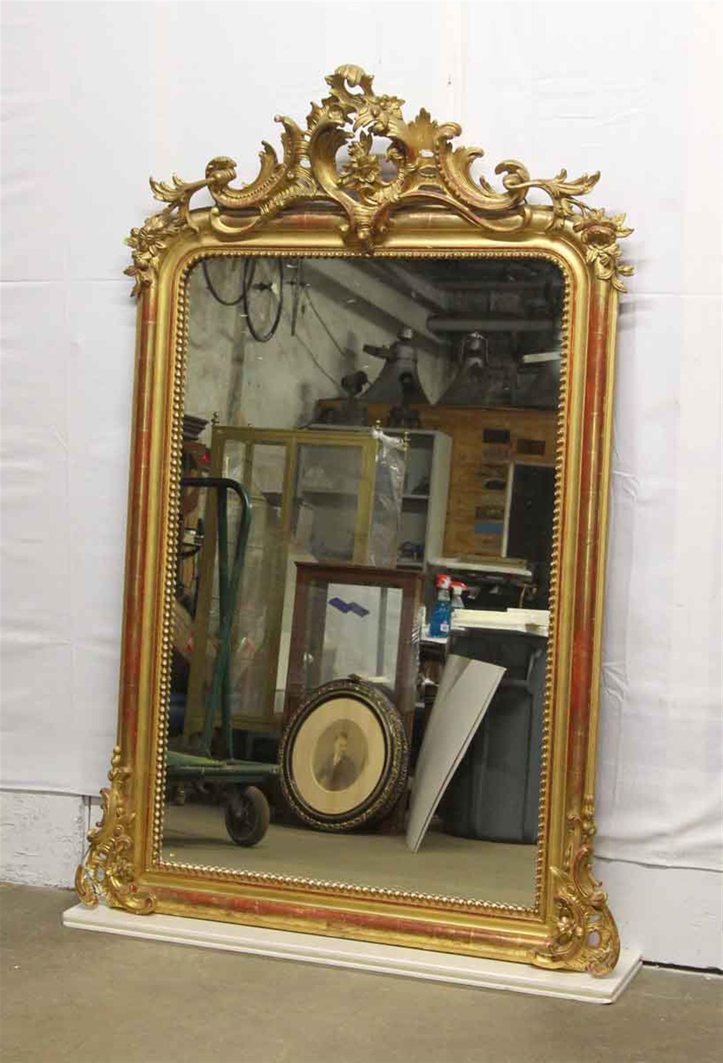 Highly ornate hand carved and gesso 1920s French gilded over mantel mirror. Manufacturer stamp on back. Floral details. Some damages. Please examine the images. This can be seen at our 400 Gilligan St location in Scranton, PA.