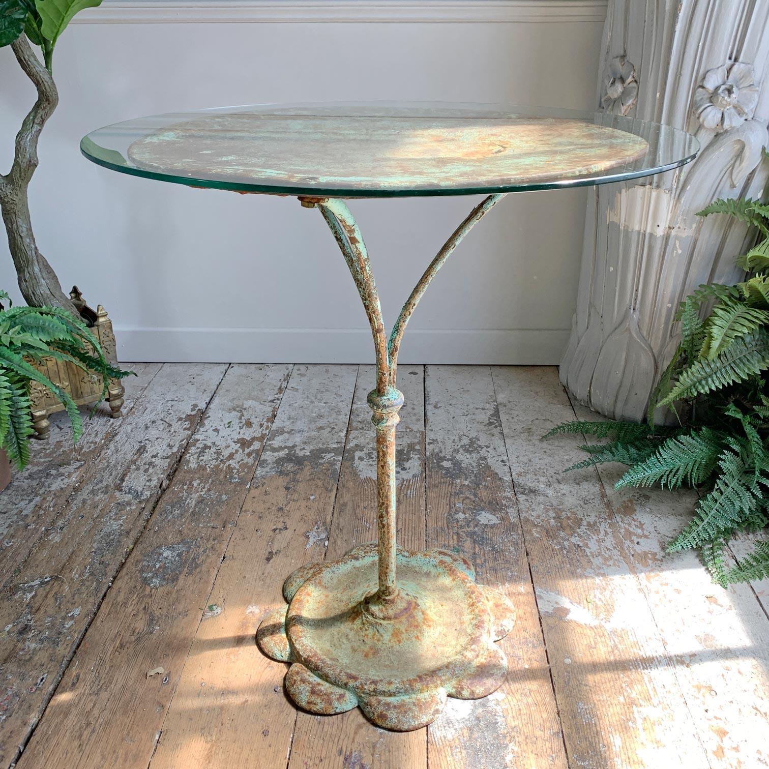 Wunderschöner französischer Bistro-/Café-Tisch aus Eisen aus dem frühen 20. Jahrhundert mit türkisfarbener Farbe und alter Patina. Die Platte hat ein paar kleine Stellen, an denen die Zeit und der Gebrauch Spuren hinterlassen haben, ist aber immer