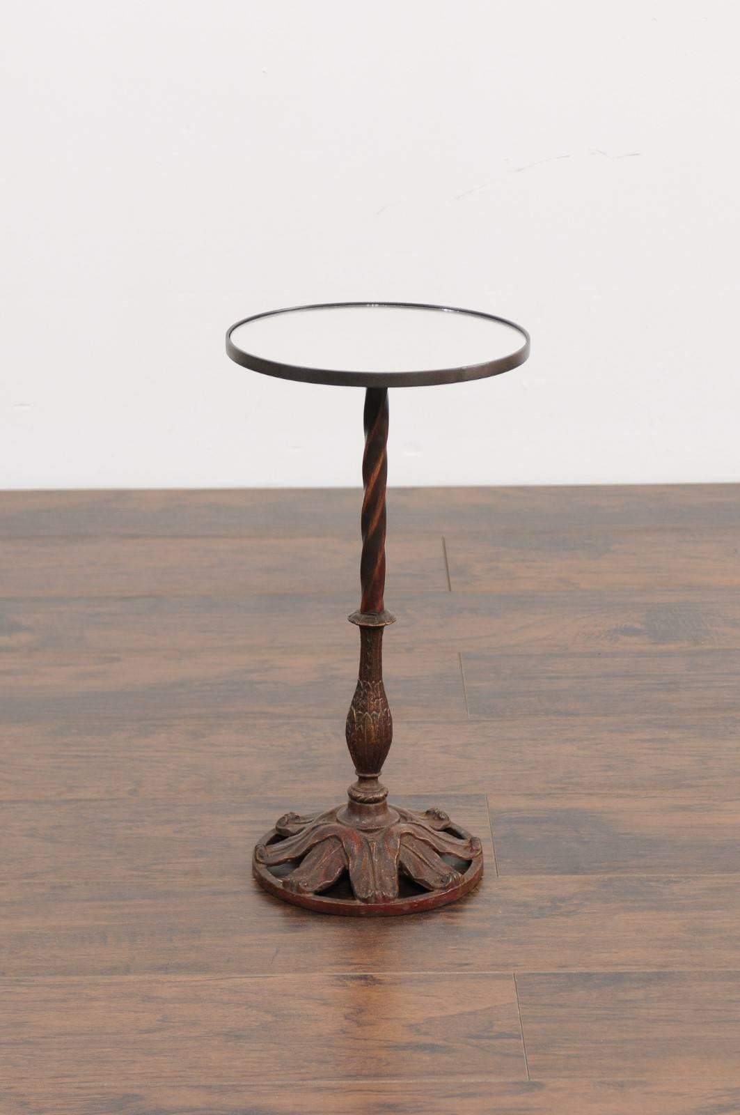 A French circular iron pedestal drink table from the early 20th century, with foliage details and new mirrored top. This French drink table features a round top, supporting a custom-made mirror. The table is raised on a delicate iron pedestal,