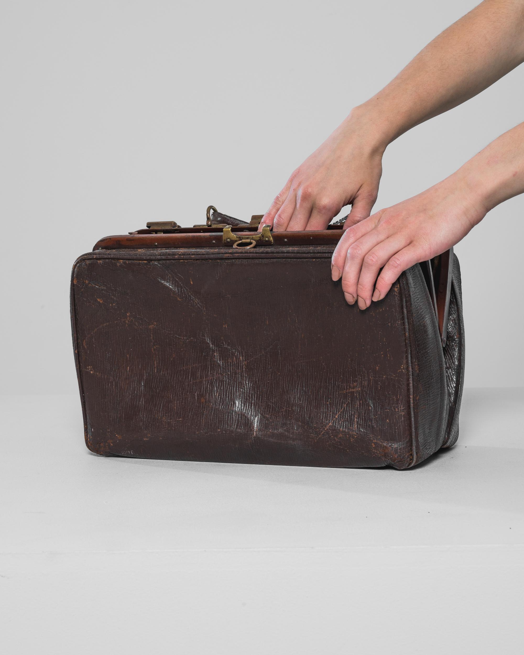 Discover the timeless elegance of this 1920s French Leather Suitcase, an exquisite piece that captures the essence of early 20th-century travel. Crafted with meticulous attention to detail, this vintage suitcase features rich, dark brown leather