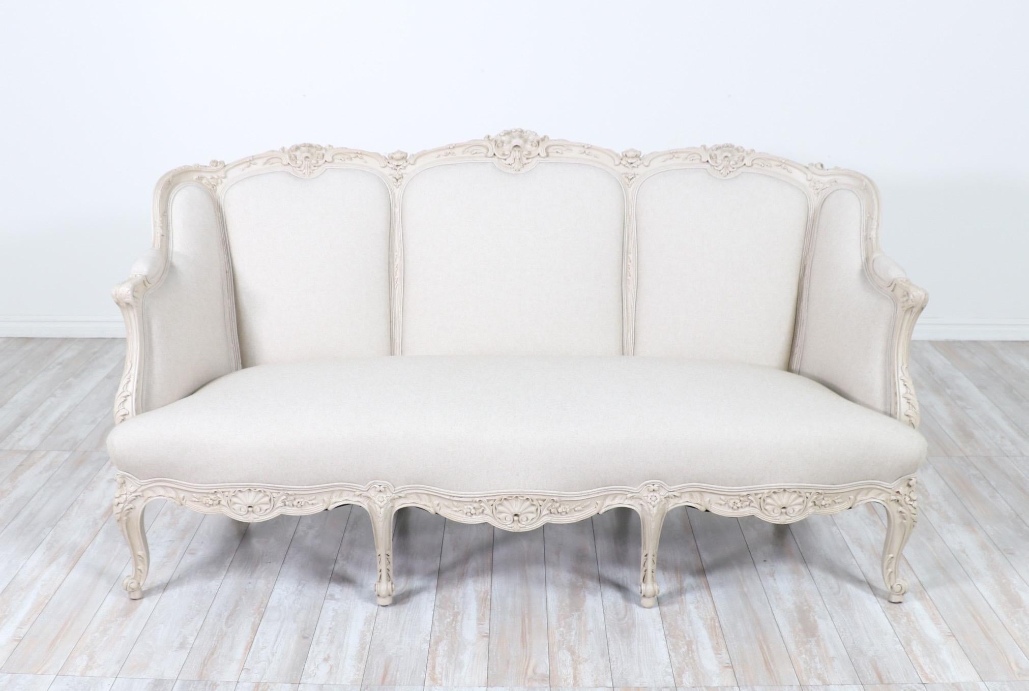 Exquisite, French 1920s Louis XV-style carved settee.

The settee features a beautifully carved wood frame with a fresh coat of greige paint and a light coat of antiquing glaze to bring out the delicate carvings. New cotton linen canvas upholstery.