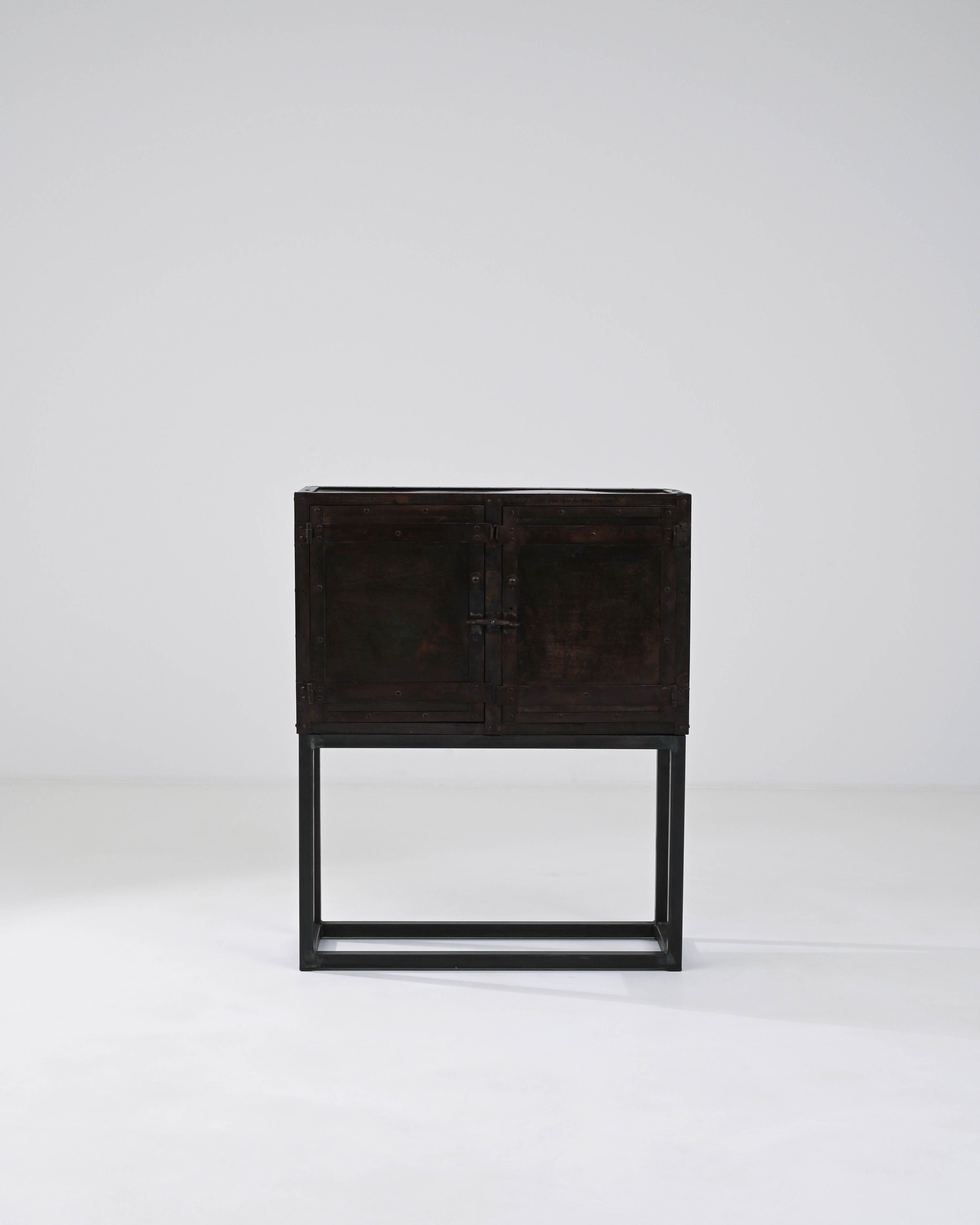 This 1920s French Metal Cabinet exudes the industrial elegance and robust character of early 20th-century design. Its minimalist metal framework provides a stark, stylish contrast to the distressed metal enclosure, creating a visual narrative of