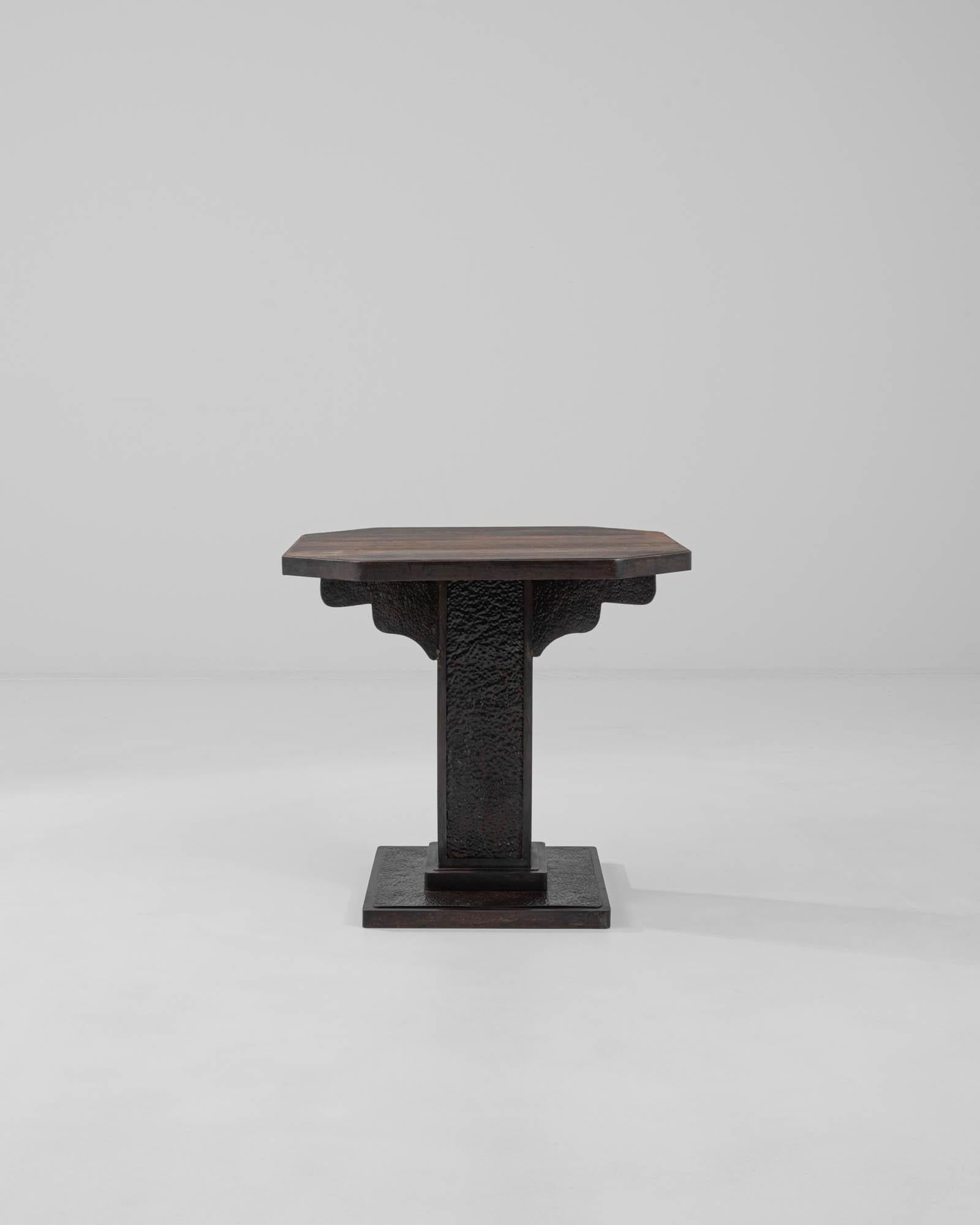 A metal side table with a wooden top made in France, circa 1900. This small gothic-inspired side table carries itself with a unique demeanor, exuding both a moody and sentimental aura through its design and thoughtful choice of materials. The metal