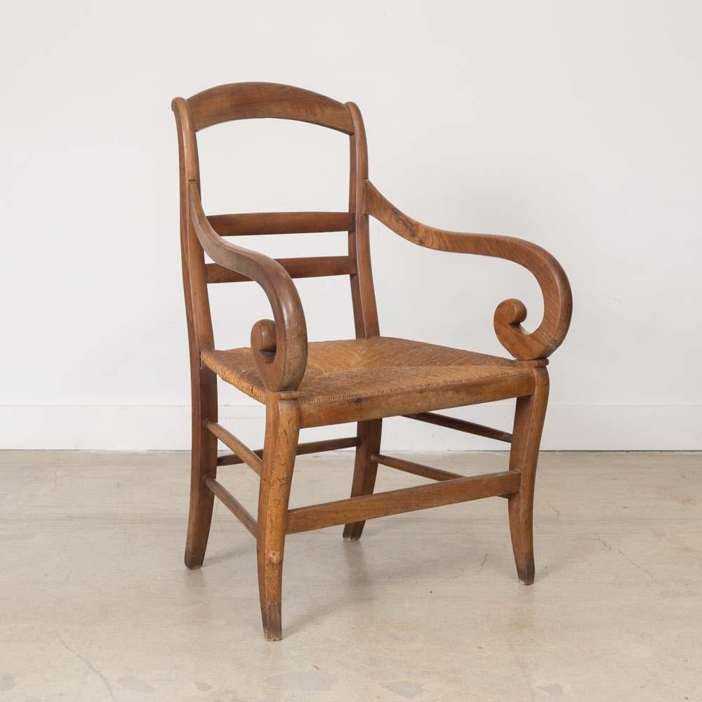 Schöner Holz- und Flechtstuhl aus Frankreich, 1920er Jahre. Geschnitzter Eichenkorpus mit schiefergedecktem Rücken und geschnitzten Schlaufen an den Armen. Fantastischer original geflochtener Strohsitz. Einzigartiges Designerstück, perfekt als