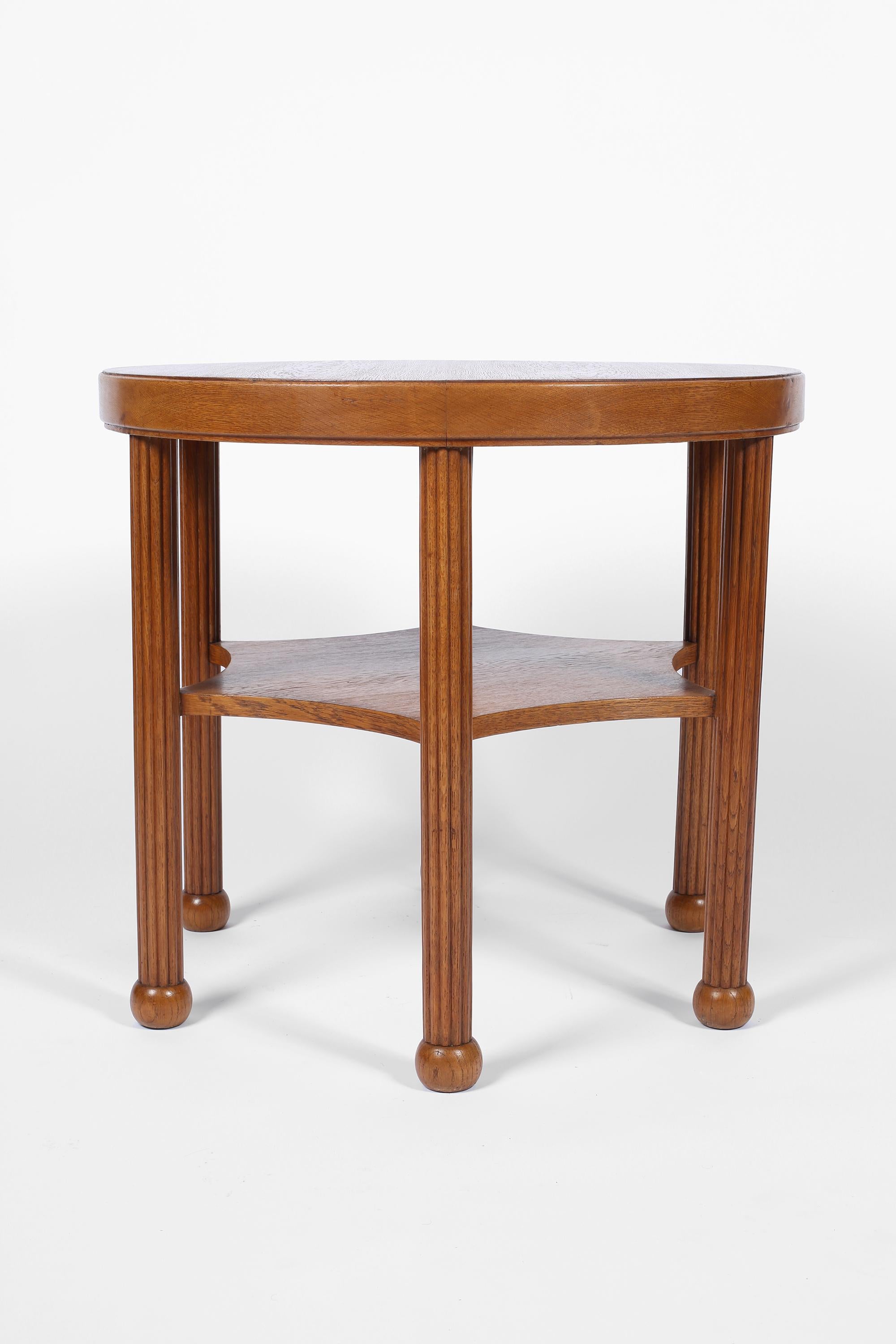 A fine early Art Deco occasional table in solid and veneered oak. The circular top sitting above a star shaped second tier, with six reeded legs terminating in carved boule feet. French, circa 1920s.