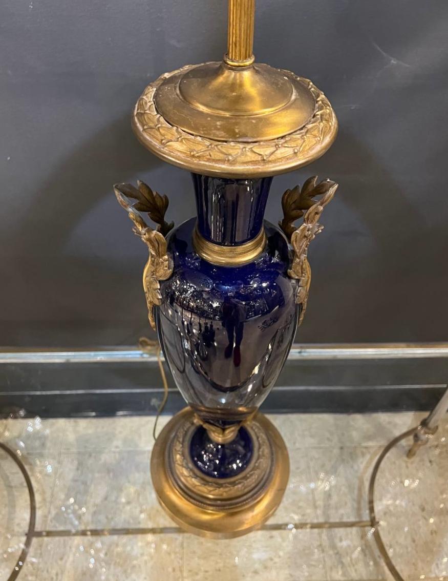 Une lampe de table en porcelaine bleue de style Louis XVI, vers le milieu du 19e siècle, avec des ferrures en bronze sur les côtés. 