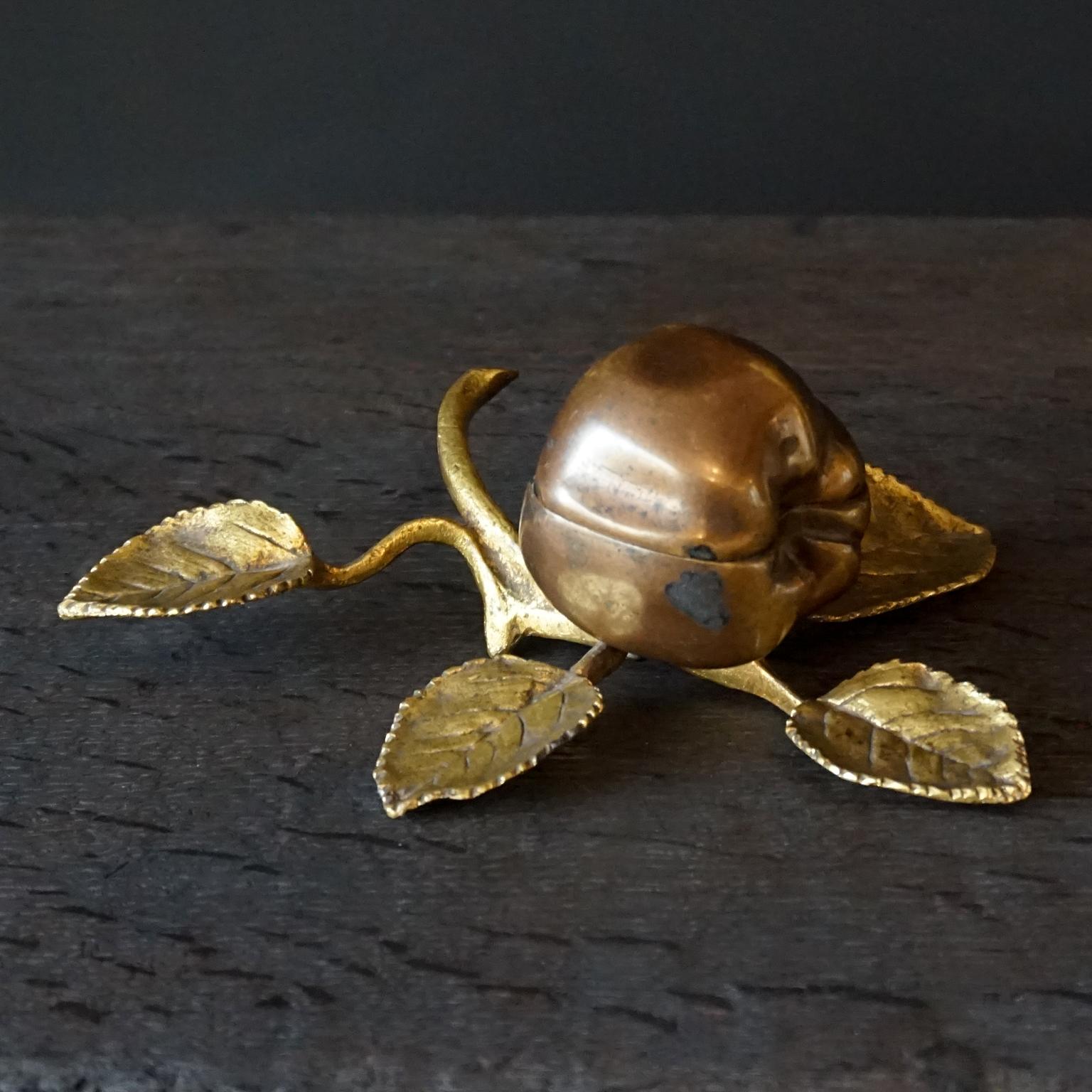 Antique hinged bronze two toned paint patinated apple on a twig with leaves, to keep or collect your little trinkets in.
This used to be called a bed-apple, for putting your jewellery in on your nightstand before going to bed. But evidently they