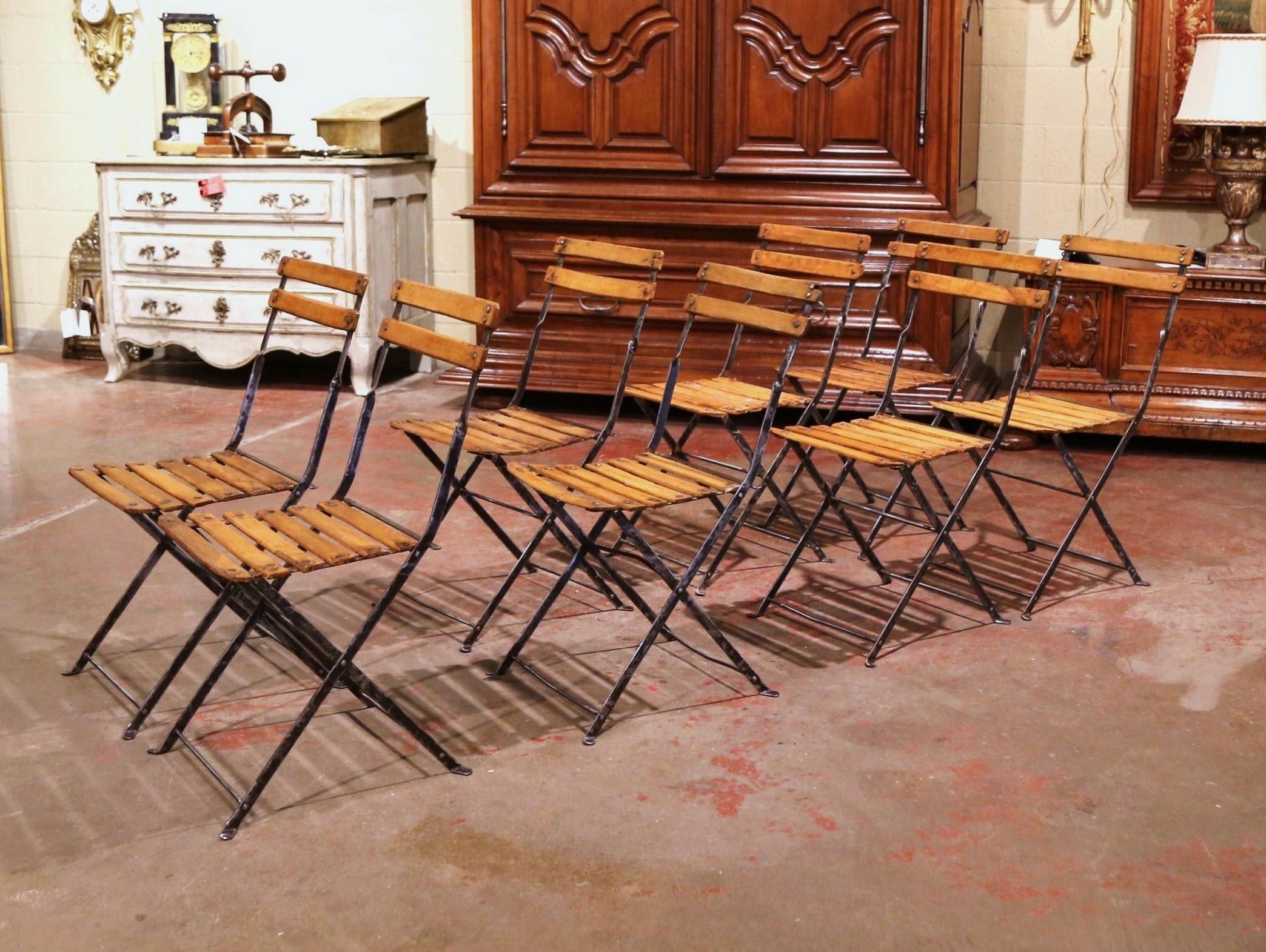 These antique chairs were crafted in Normandy, France, circa 1920. Made of iron and pine, each chair has a two-ladder back and six-slat seat, and features a folding mechanism for ultimate compact storage (less than 2