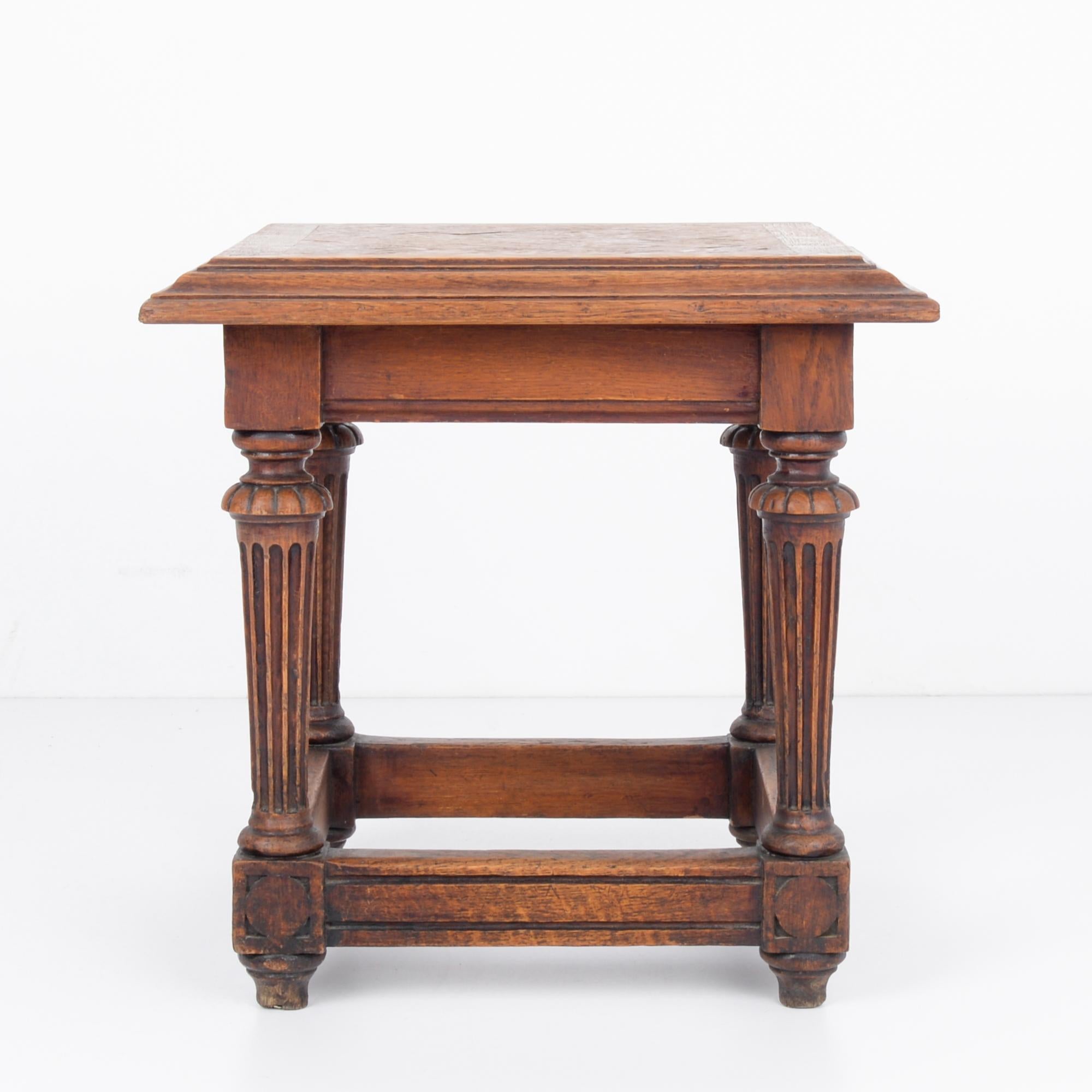 This wooden side table with a rich and warm tone was made in France, circa 1920. It displays the symmetry and bold lines of the art Art Deco era, integrated with classical French features-- ridges on the angular stretchers and the checked pattern on