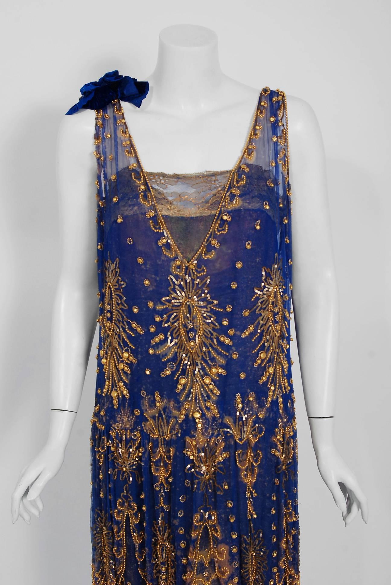 Undiminished by time, this 1920's royal-blue and gold dance dress still casts its seductive spell. This exceptional Art Deco beauty is fashioned in three different French couture fabrics- sheer silk chiffon, metallic gold lace and lamé based