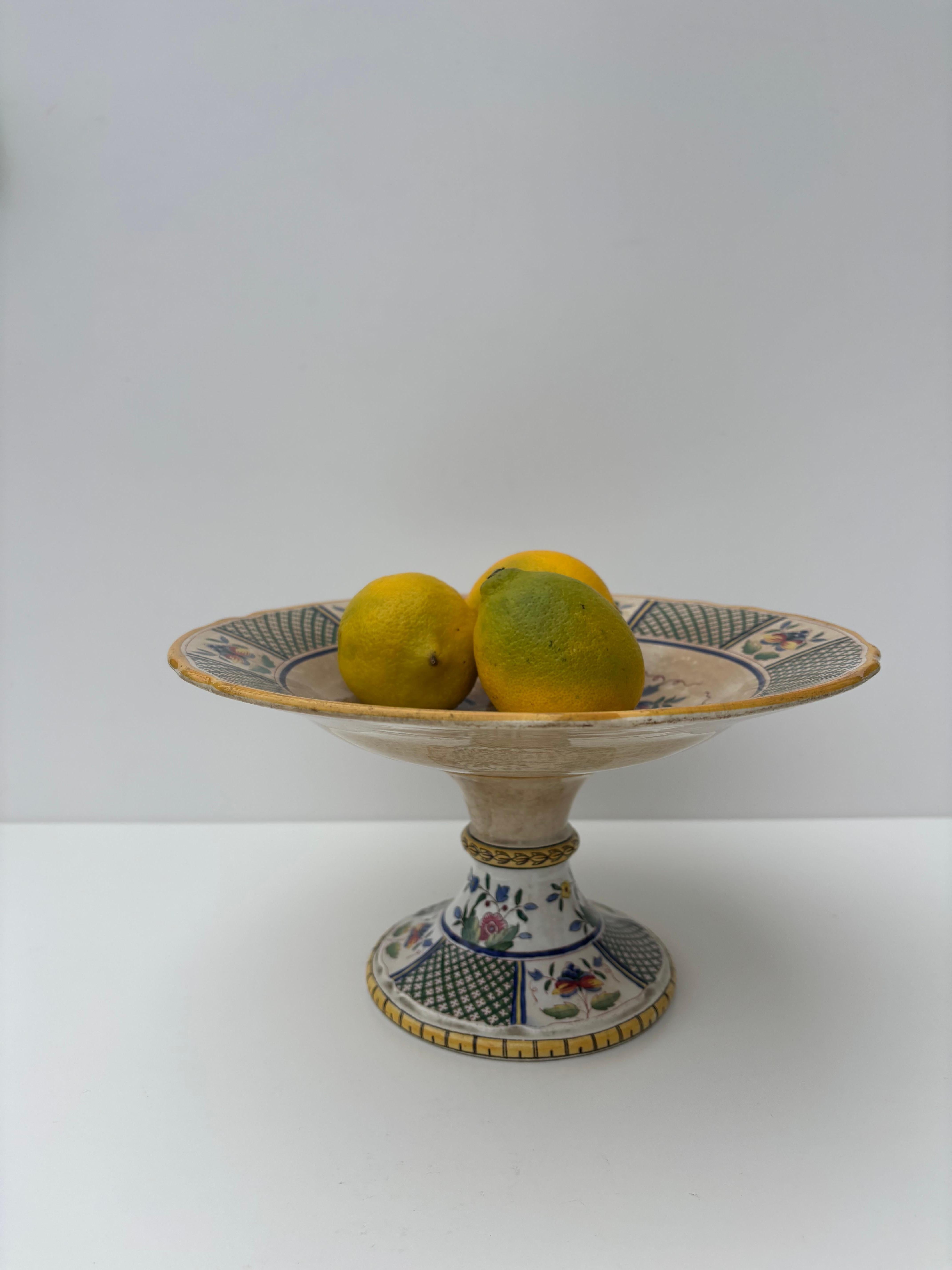Ancienne coupe sur pied de Sarreguemines à décor floral et géom�étrique coloré. A utiliser comme plat de service, support à gâteau ou centre de table décoratif. Estampillé sous la base. 
Belle condition vintage. 
France, vers les années 1920. 