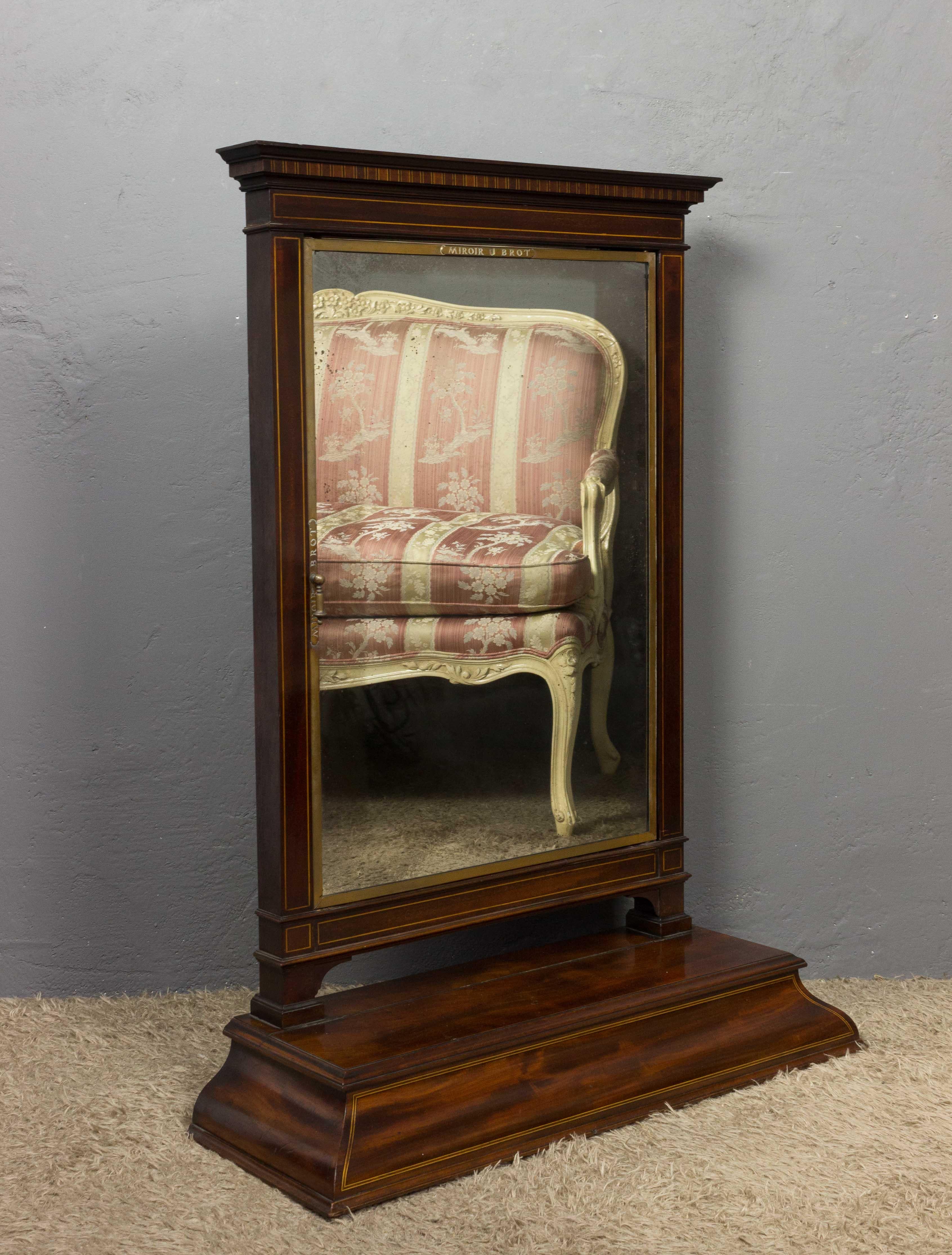 Triptych vanity mirror by Brot housed in a mahogany wood frame with storage box. A special detail of this piece is the boxwood inlays adorning the top and base of the wood frame.