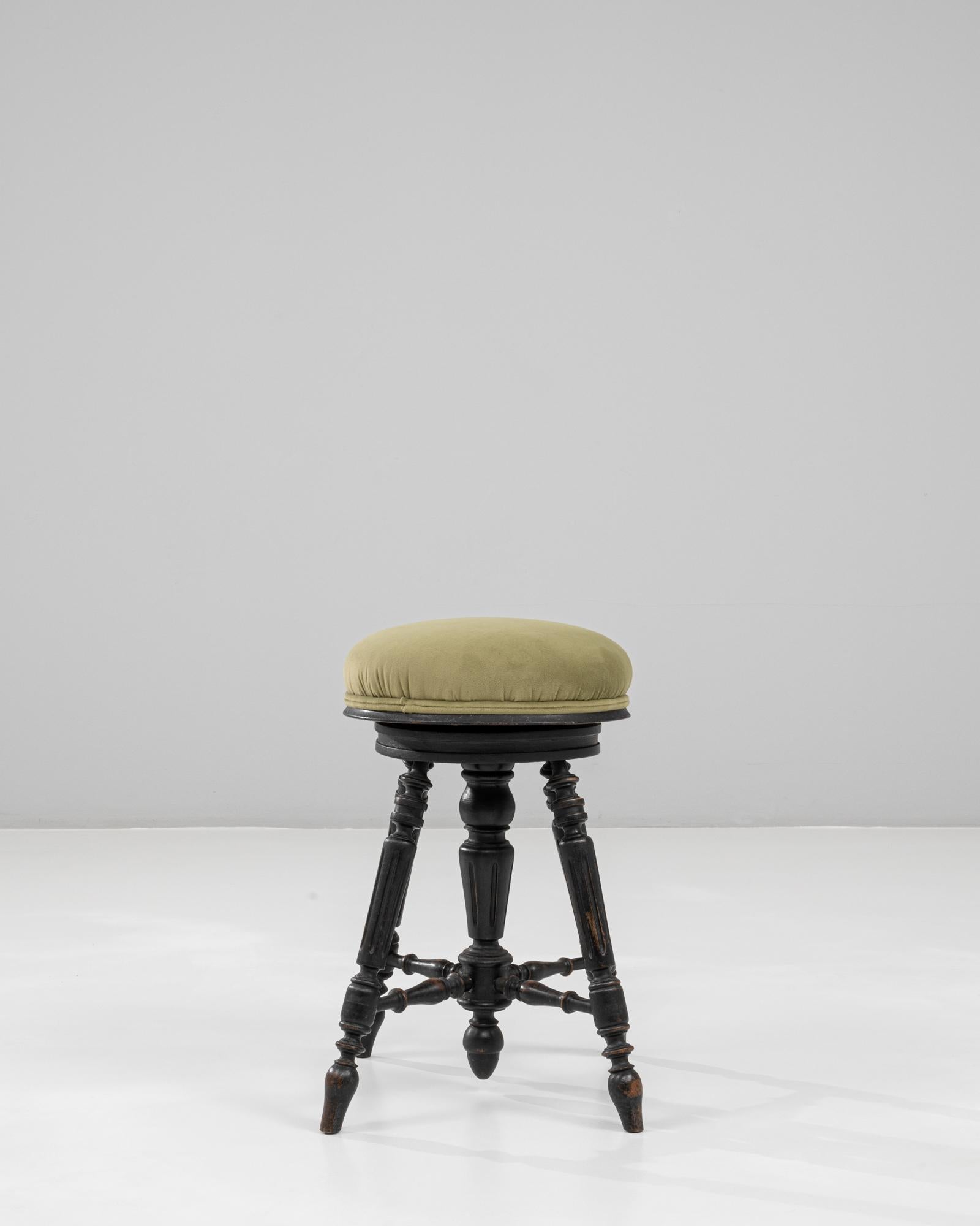 Questo sgabello per pianoforte imbottito francese vittoriano degli anni '20 presenta una base in legno splendidamente intagliata con gambe tornite collegate da eleganti barelle. La finitura nera dello sgabello ha acquisito una ricca patina nel corso