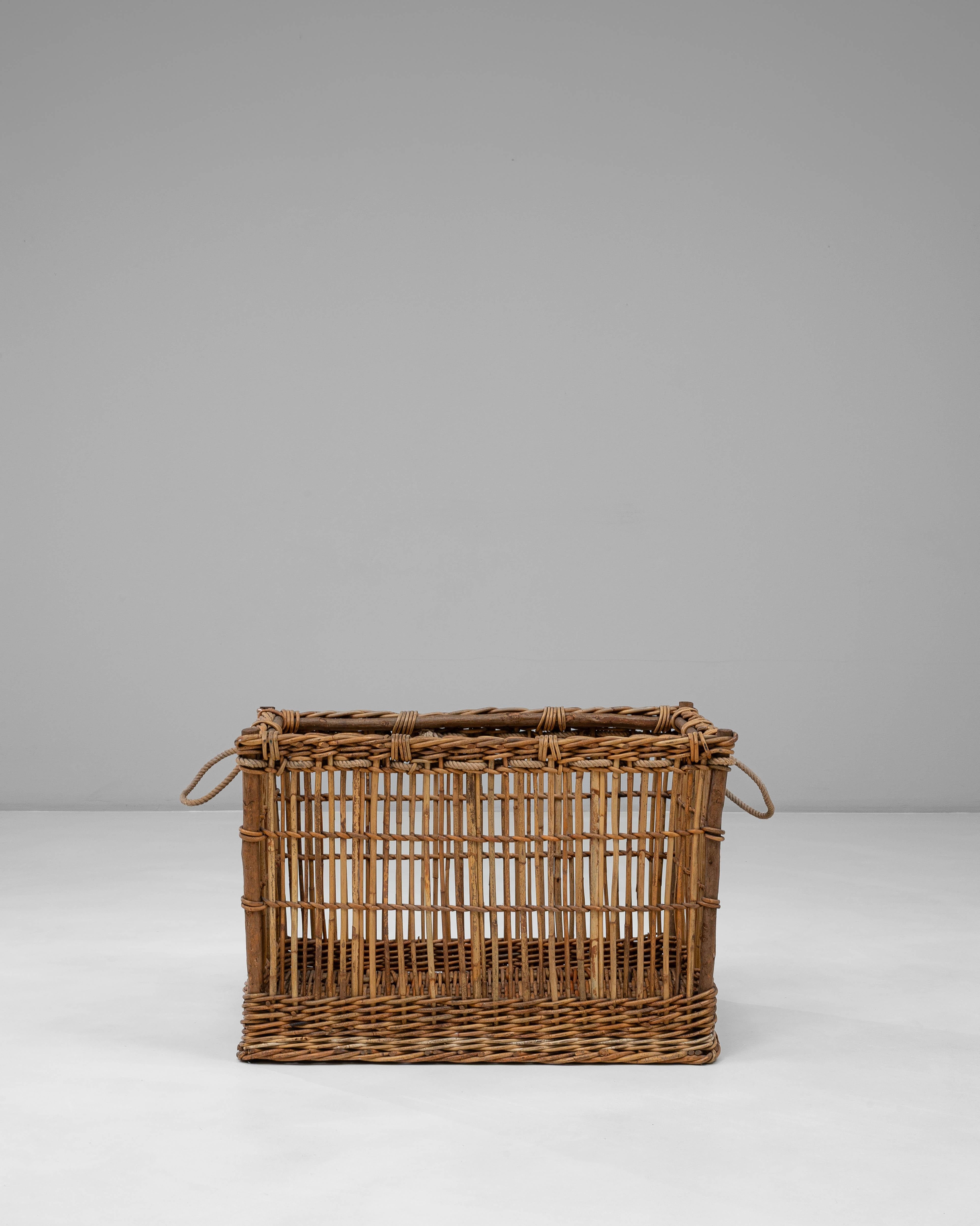 Esta cesta francesa de mimbre de los años 20 muestra el encanto de la artesanía utilitaria de principios del siglo XX, con su estructura aireada de trama abierta y su cálida pátina envejecida de forma natural. La cesta está construida con robustas