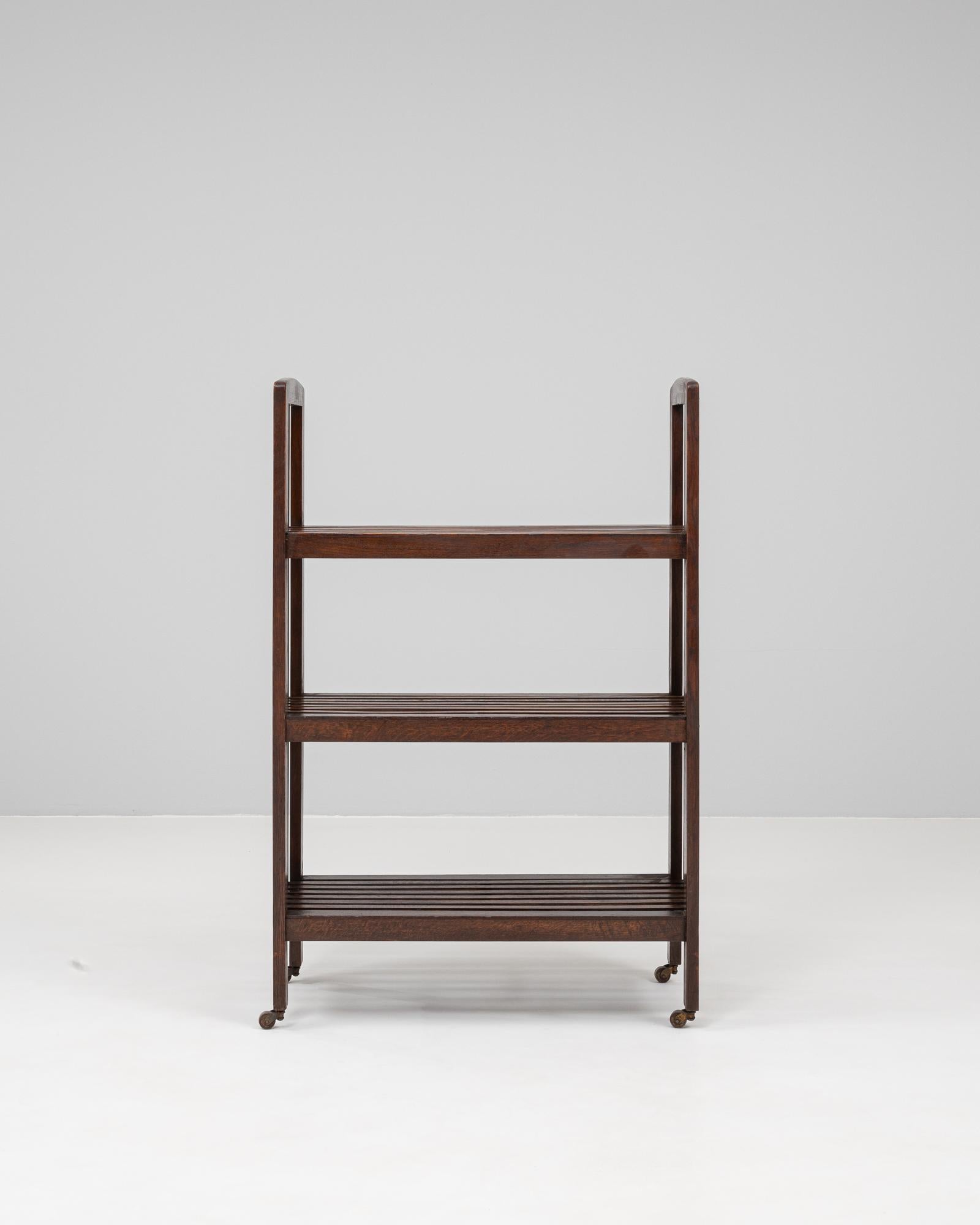 Questa libreria francese in legno degli anni '20 combina un'elegante lavorazione artigianale con un design funzionale. Realizzato in legno massiccio, presenta tre ripiani a doghe incorniciati da listelli verticali che gli conferiscono un aspetto