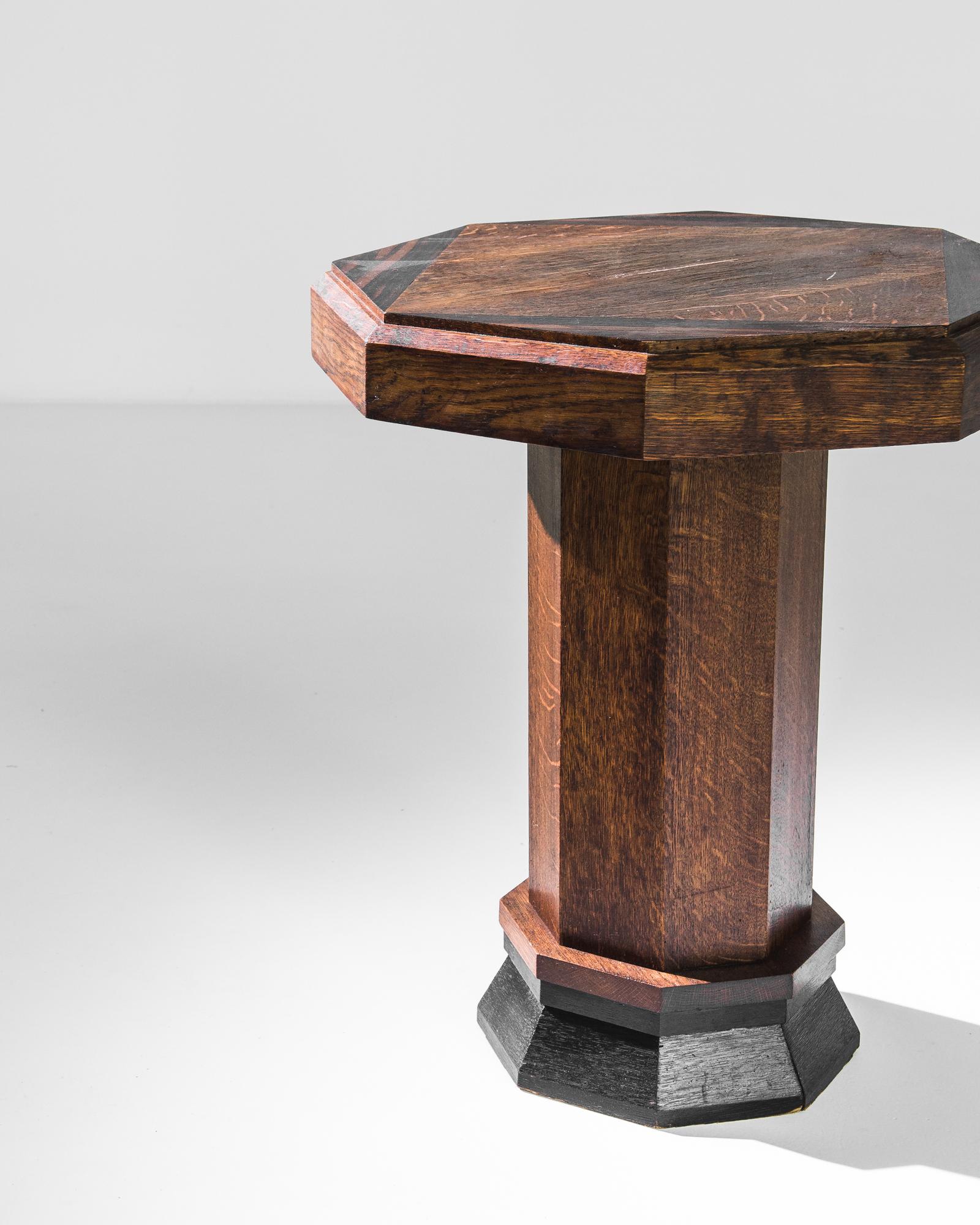 The octagonal shape of this wooden side table creates an eye-catching silhouette. Made in France in the 1920s, the wood retains its original patina: a deep tawny color with a rich polish. Triangular inlays accentuate the angles of the eight-sided