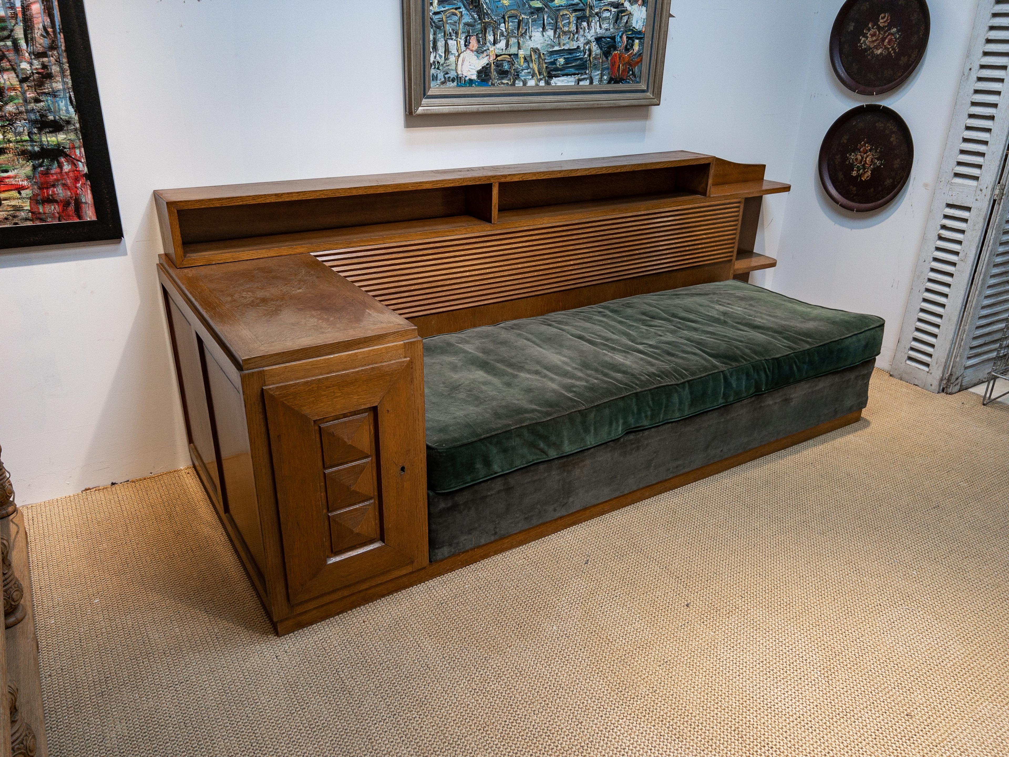 The 1920s Gaston Poisson day bed is an exquisite blend of form and function, a hallmark of the era's design ingenuity. This piece boasts a luxurious velvet upholstery that exudes both comfort and opulence, inviting repose in the lap of elegance. Its