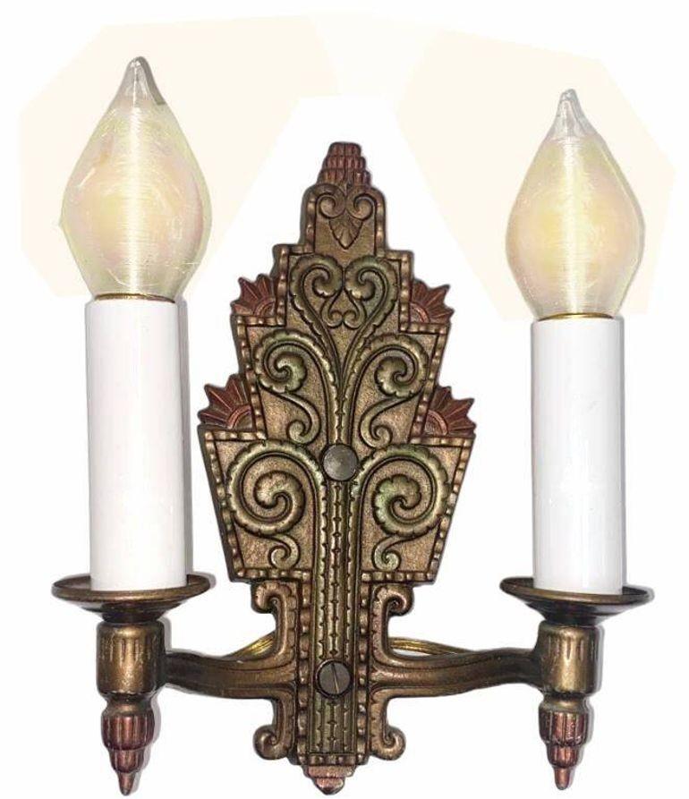 Questa originale applique a doppia luce in bronzo Art Deco incarna il design ornato e precocemente ispirato al Bauhaus. Realizzata in ottone massiccio con una calda finitura anticata, l'applique presenta spesso dettagli intricati, come volute