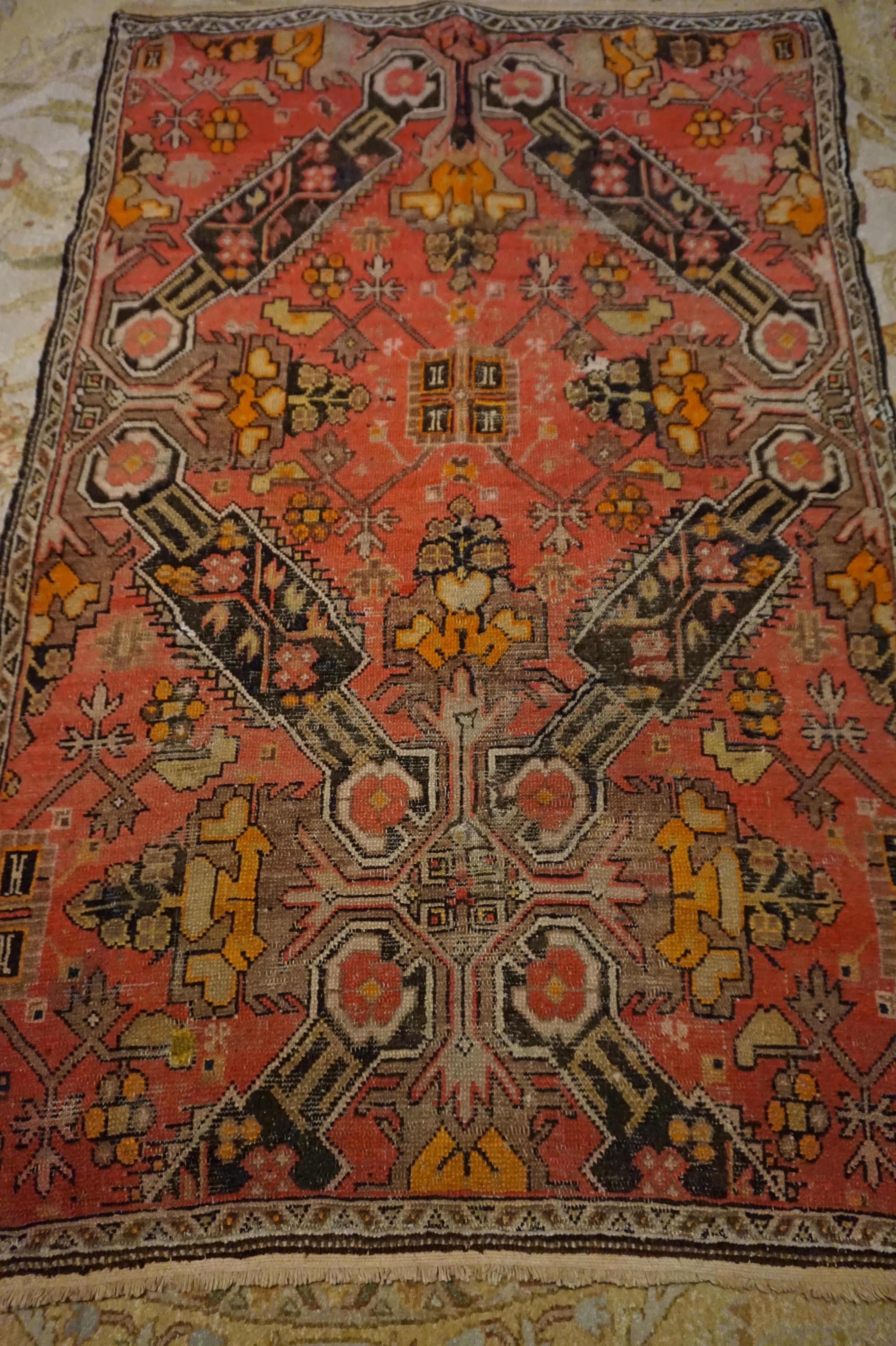 Rare Georgia Caucasus Rug in salmon and pink tones with kite shaped medallions encasing a floral geometric theme. Overall condition is time honoured but with lots of life to offer. Well conceived pattern oozing with warmth and rustic charm. Compact
