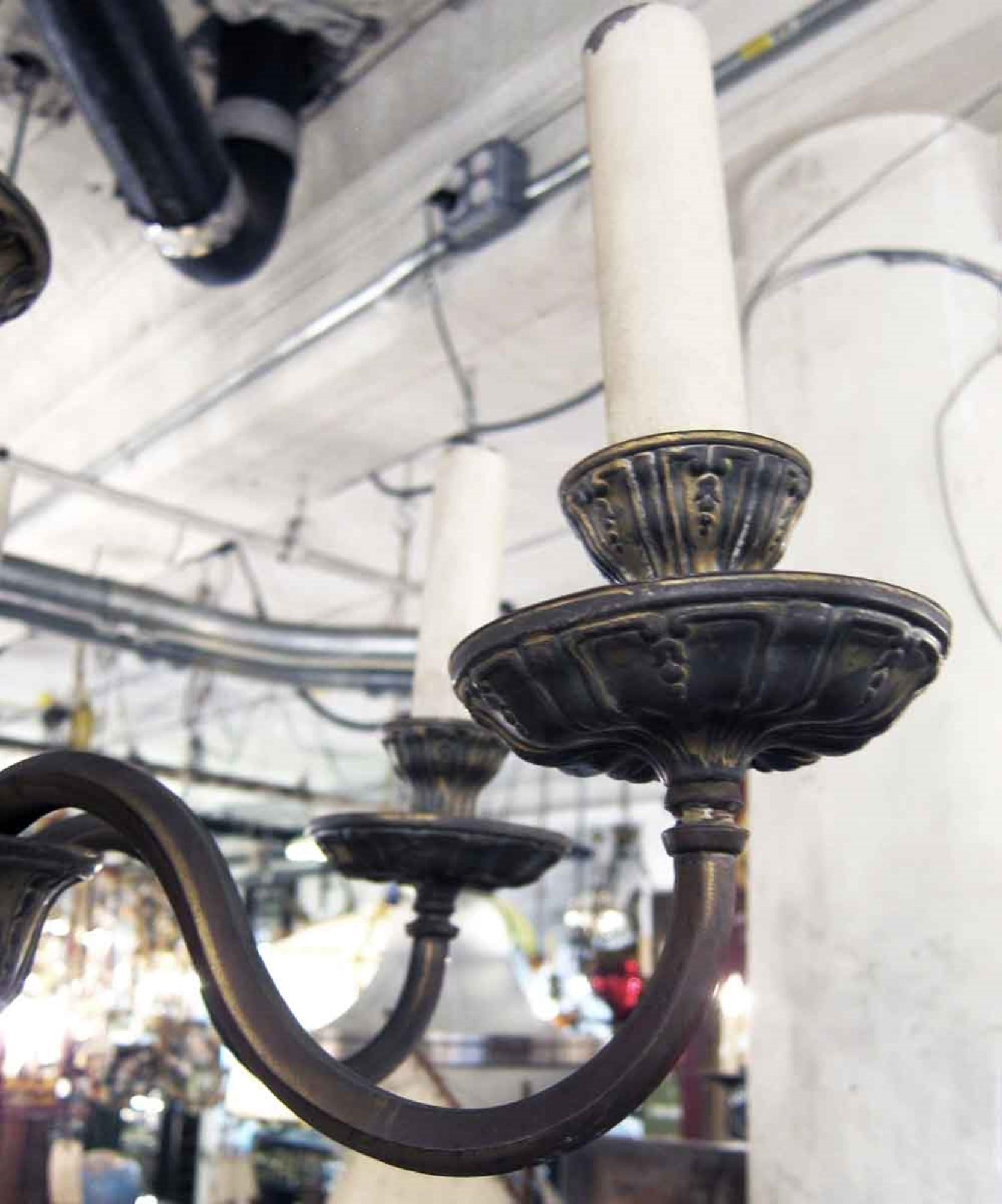 Georgian style chandelier made of cast and stamped brass from the 1920s featuring six arms. This can be seen at our 400 Gilligan St location in Scranton. PA.