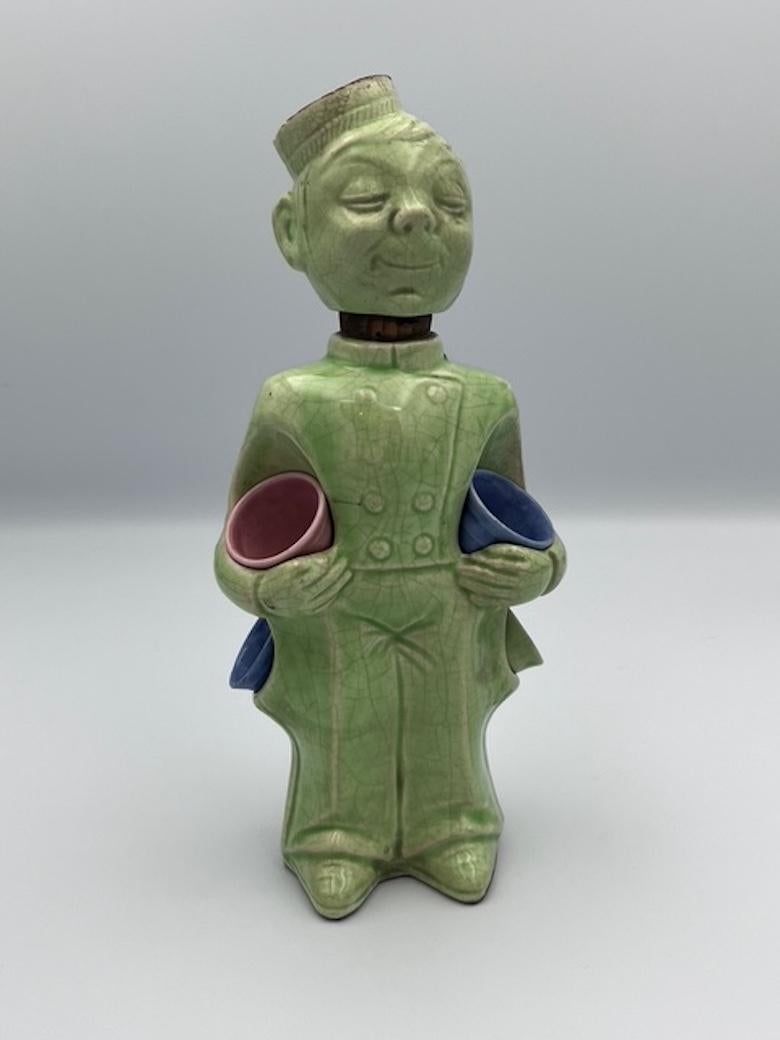 Raro decanter tedesco Art Deco Bellhop con bicchieri da shot

Questo affascinante decanter da campanaro in porcellana smaltata è un delizioso e raro esempio di design Art Deco tedesco. Il decanter è rifinito con un morbido smalto verde menta, con