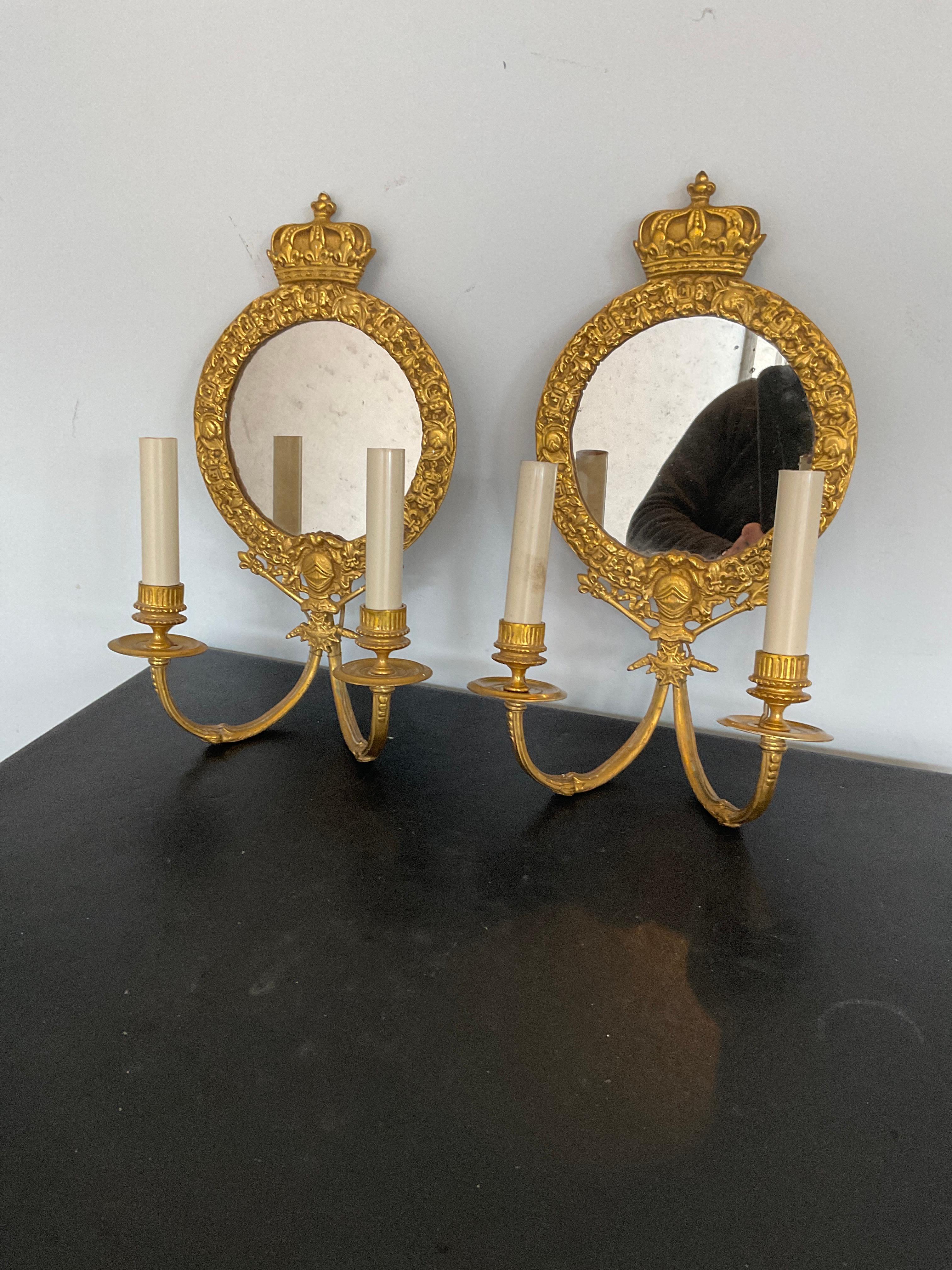 Pair of 1920s gilt bronze mirrored Knight sconces with crown tops. Out of a Greenwich, Connecticut estate.