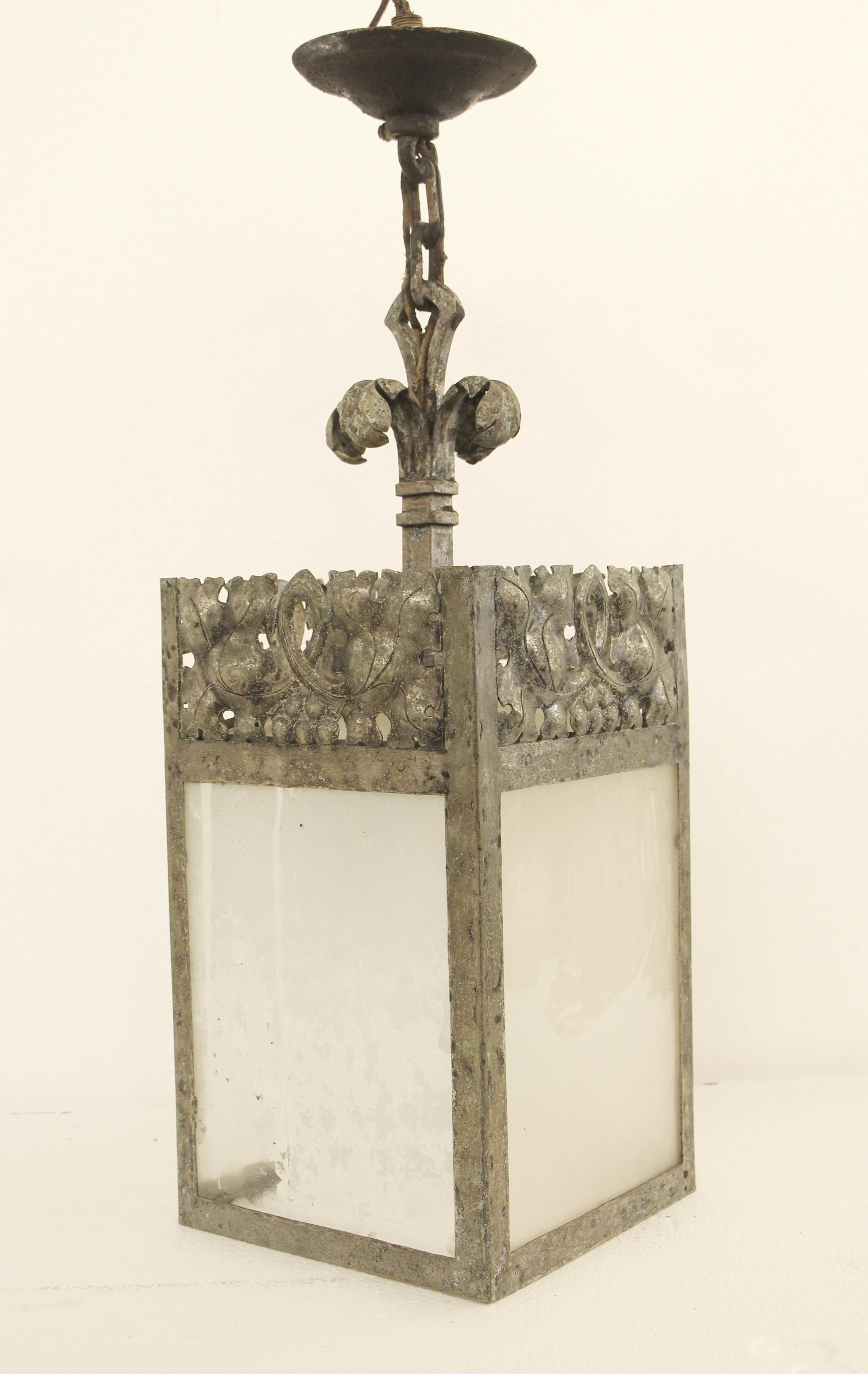 1920s wrought and hammered steel decorative lantern with frosted glass panels. There is wear from age and use and the lantern is sold in as is condition. Pewter-like finish. Some frosting coming off the glass panels. Please see photos. This can be