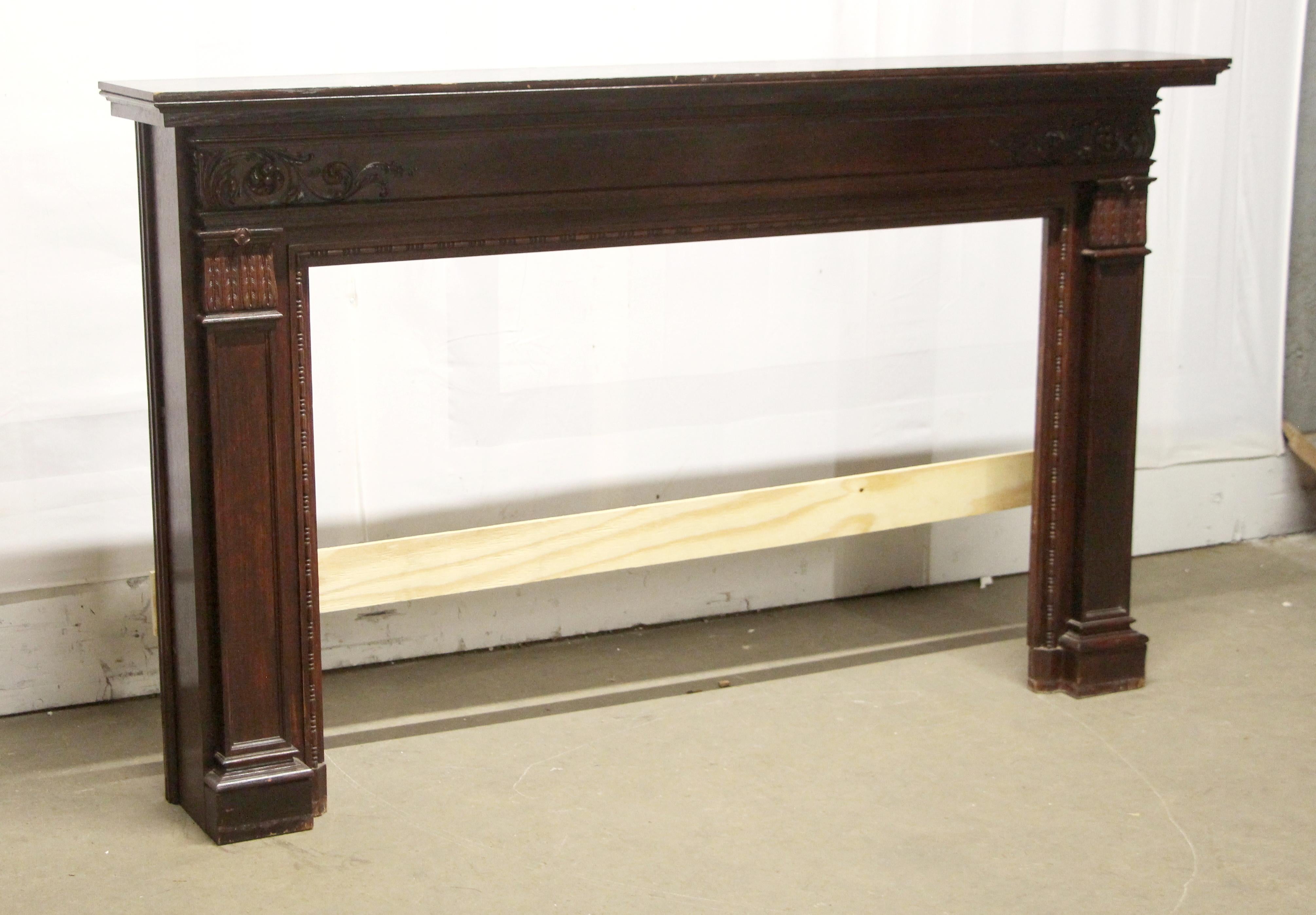 Large wooden Federal style mantel with a dark mahogany finish and decorative carvings. There is general wear from age and use. This can be seen at our 302 Bowery location in NoHo in Manhattan.