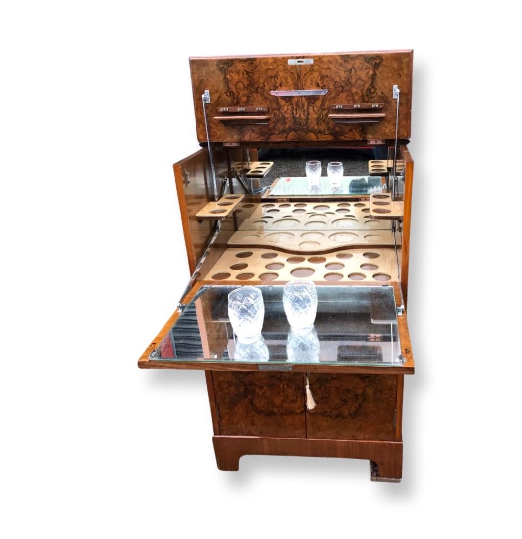 Gorgeous cocktail cabinet dating to the 1920s veneered in the most stunning bookpaged figured walnut to the top and front with long grained figured walnut to the sides. The whole is a lovely rich deep honey colour. To access the upper section the