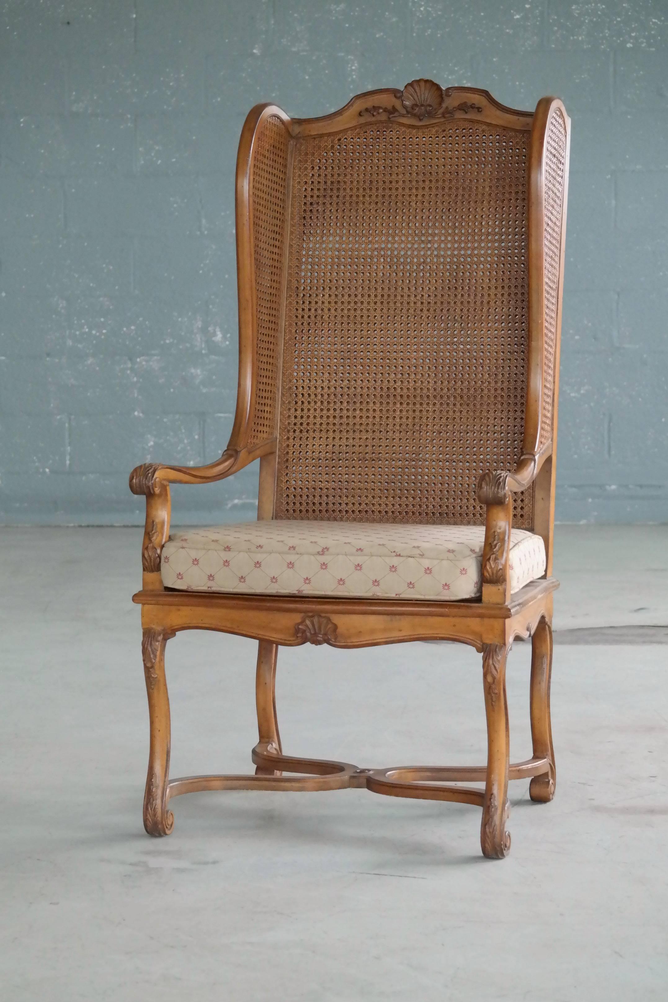 Super stylish 1920s American Hollywood Regency tall wingback chair in rare double cane. The chair shows appropriate age wear in the form of minor nicks and scuffs while the cane is in very near perfect condition. The chairs were part of the set