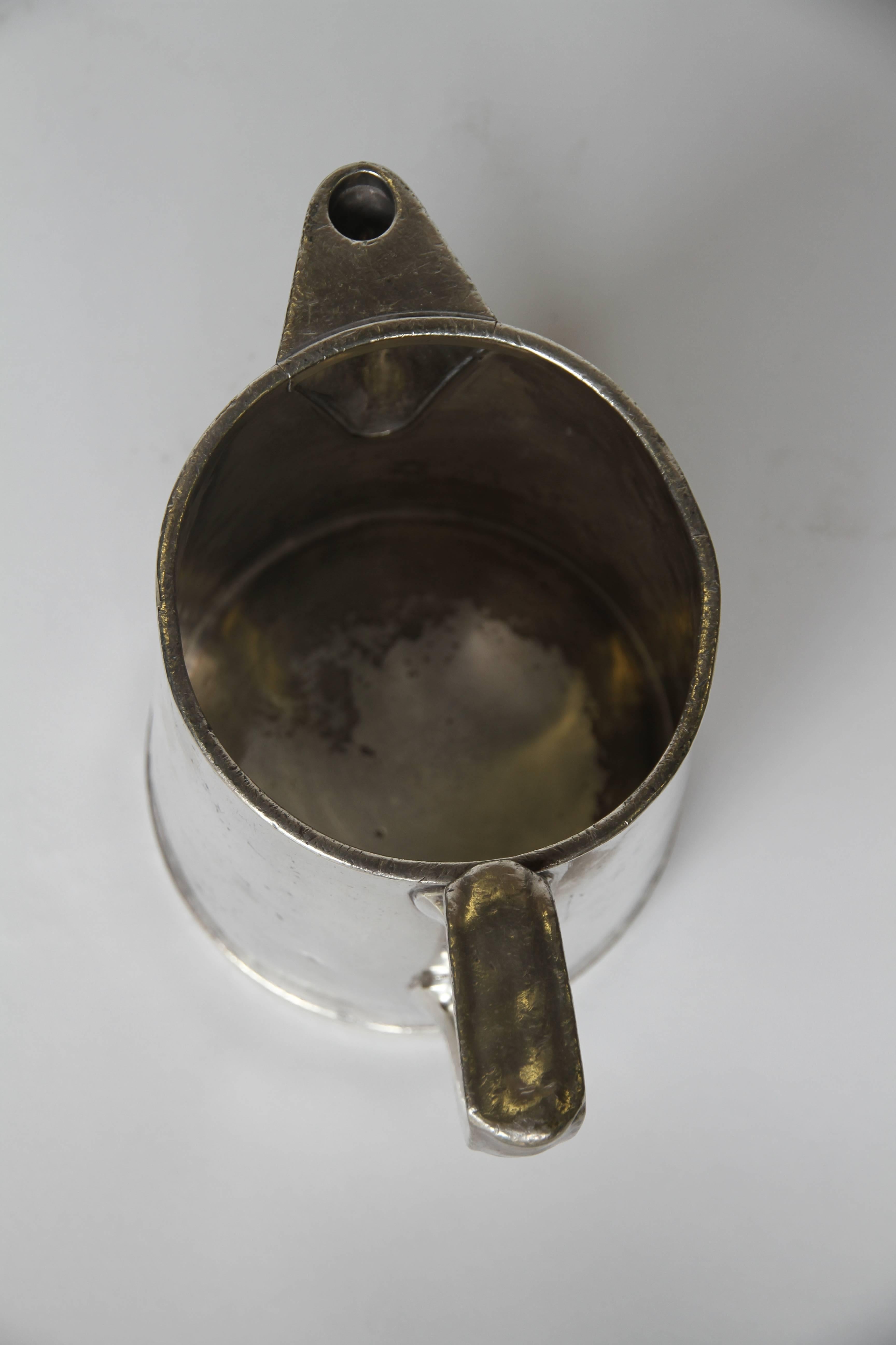 A silver soldered pitcher made by Reed and Barton for the University of Notre Dame. With a classic shape these pieces were made extra dense and heavy so as not to spill when in use. Marked Reed & Barton, Sliver Soldered and University of Notre Dame.