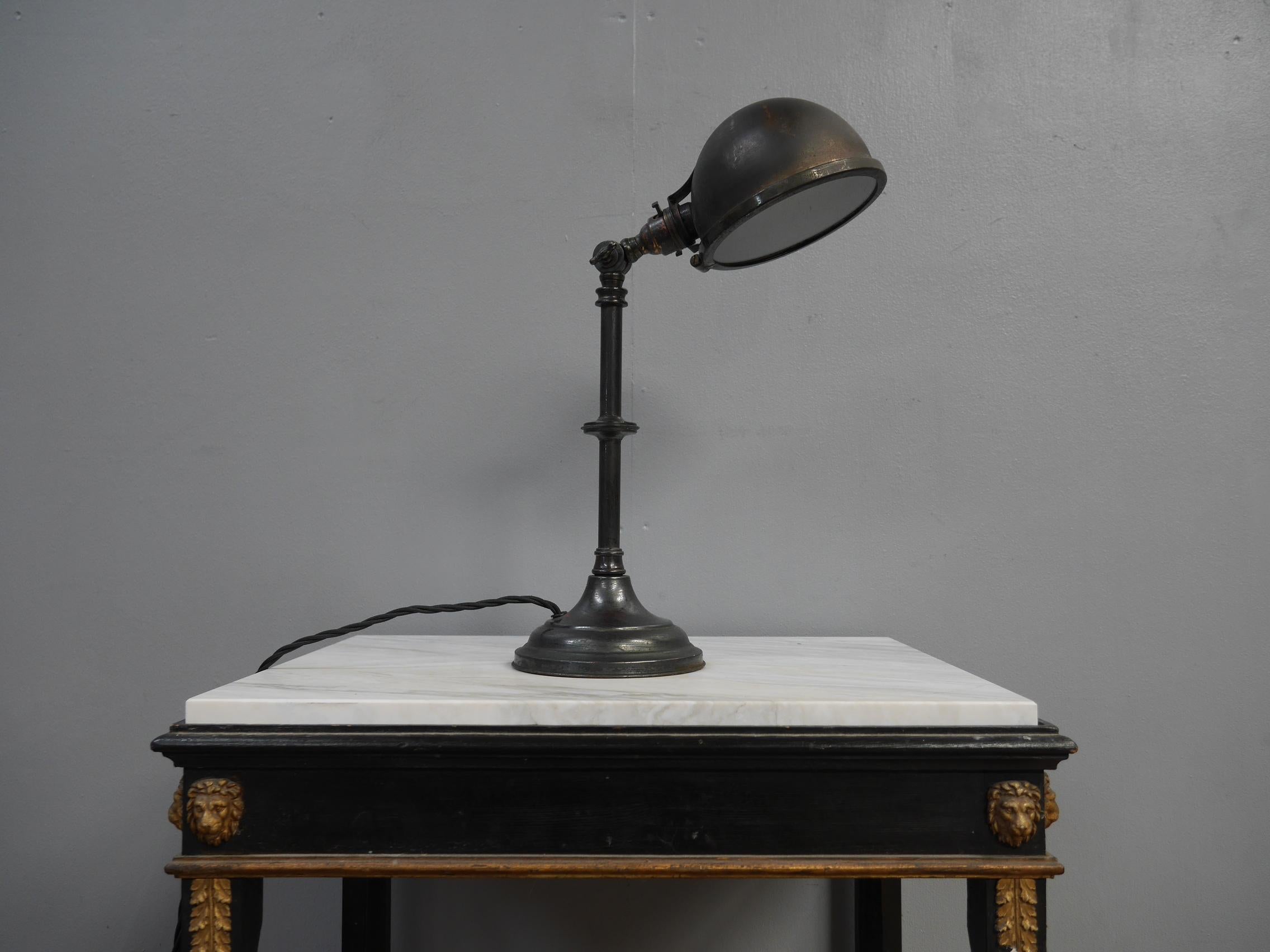 An early English industrial desk lamp.
A particularly good articulated desk lamp in dark nickel plated copper with an excellent patina. The base is weighted with cast iron & the underside of the riveted, spun copper shade has removable glazing.
An