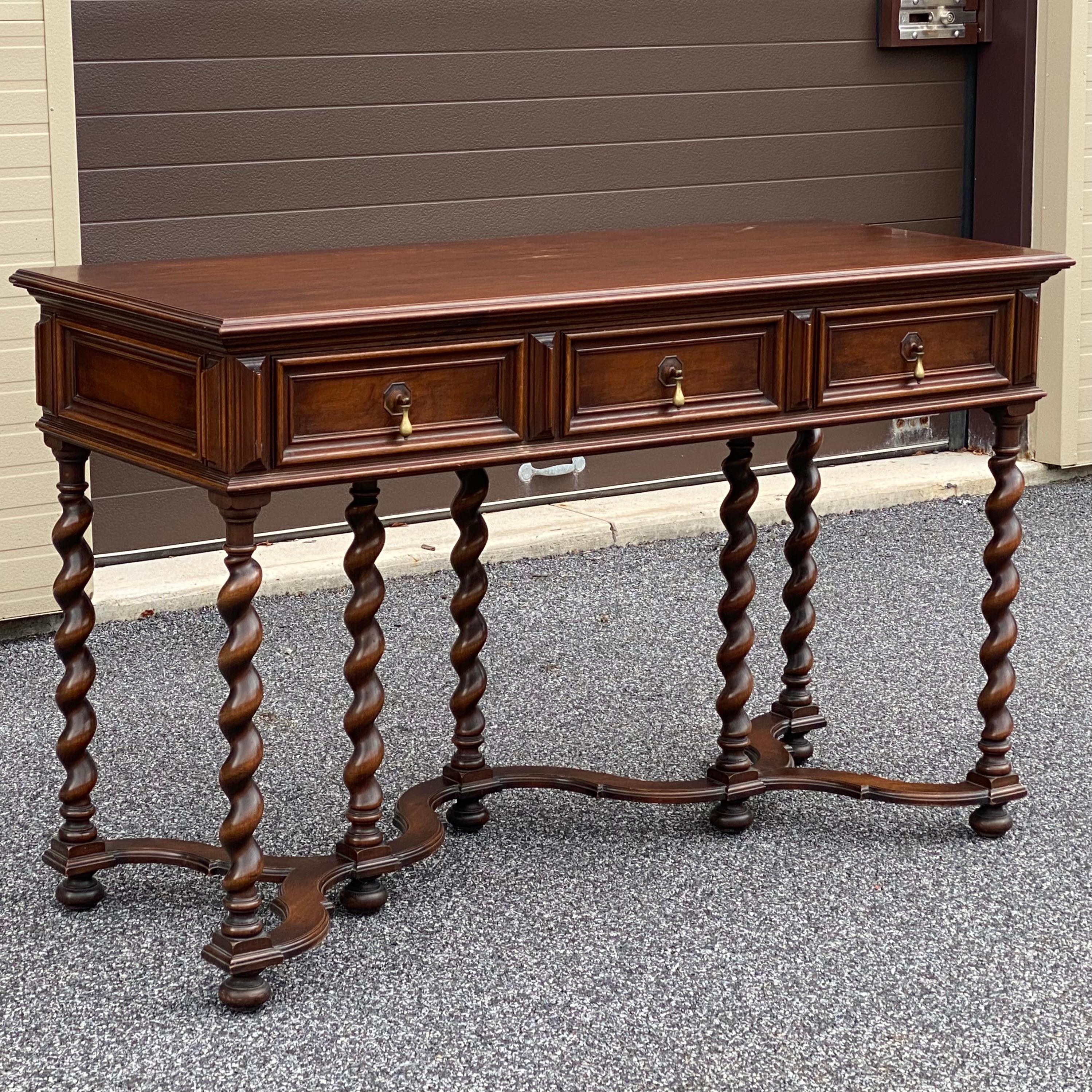 Beautiful antique solid walnut console table or desk having three finely dovetailed drawers with brass drop hardware and seven barley twist legs with curved stretchers. Custom made by Irving & Casson for client Thomas Halloran in May 1922.