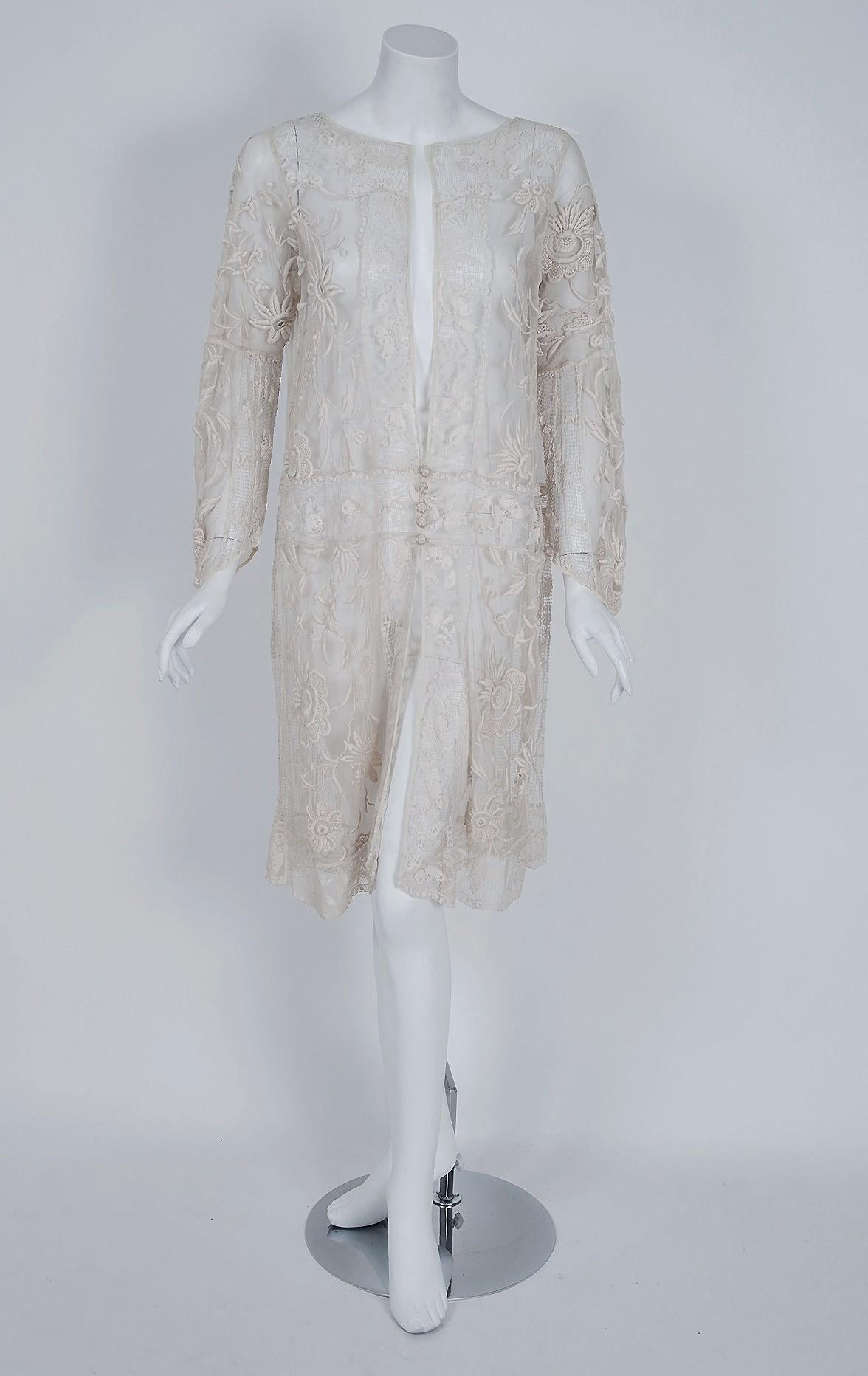 This is an early 1920's ethereal masterpiece. The unique unstructured style is strikingly modern yet the abundance of handmade filet crochet-lace and embroidered floral sheer-net is a treasure trove of antique needle art. Just look at the