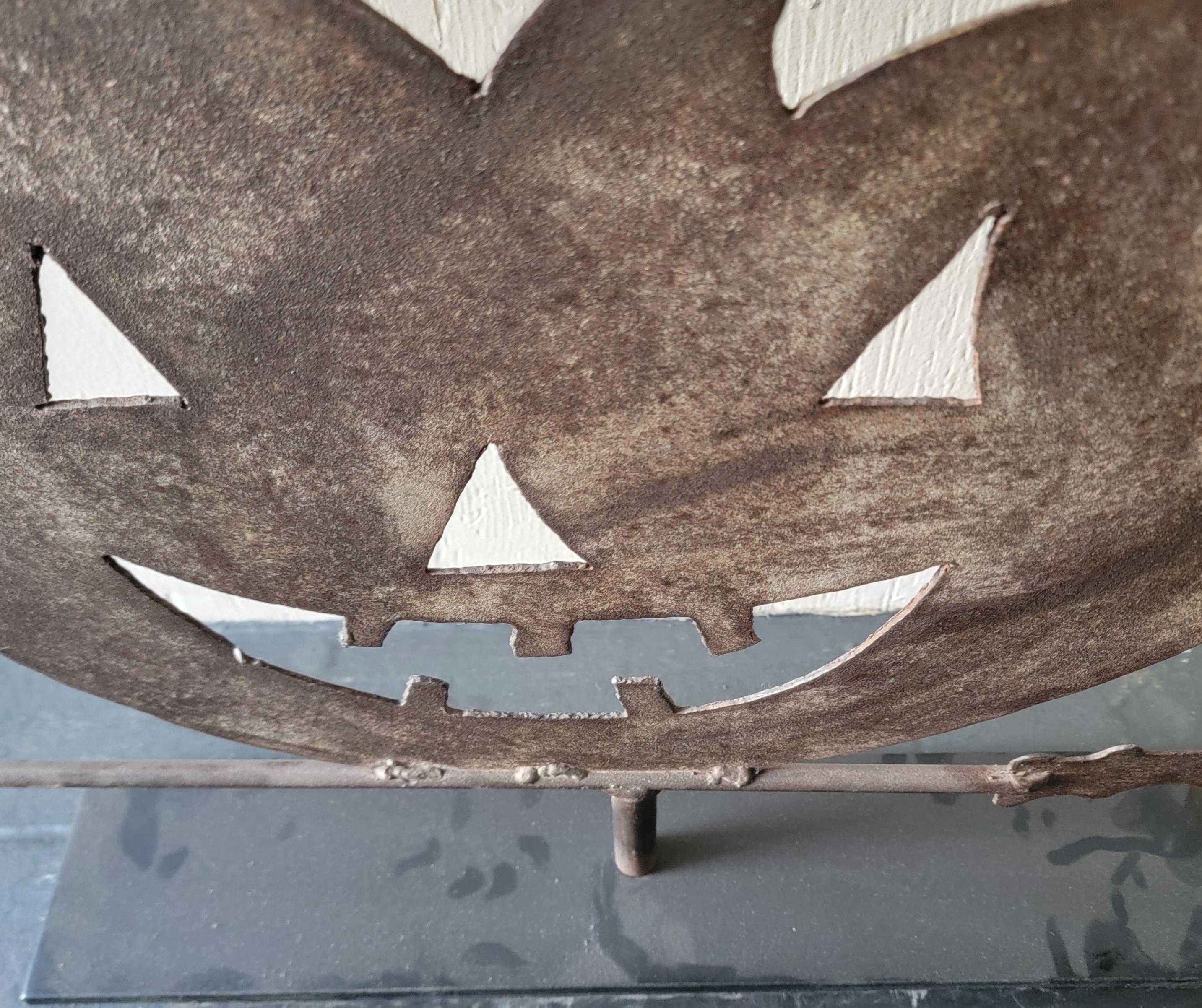 Paletta in lamiera di ferro degli anni '20 raffigurante una lanterna a forma di cricco su una paletta di scopa di streghe. Questa banderuola in ferro presenta una meravigliosa patina invecchiata. Questa banderuola è stata trovata nel Mid-West.