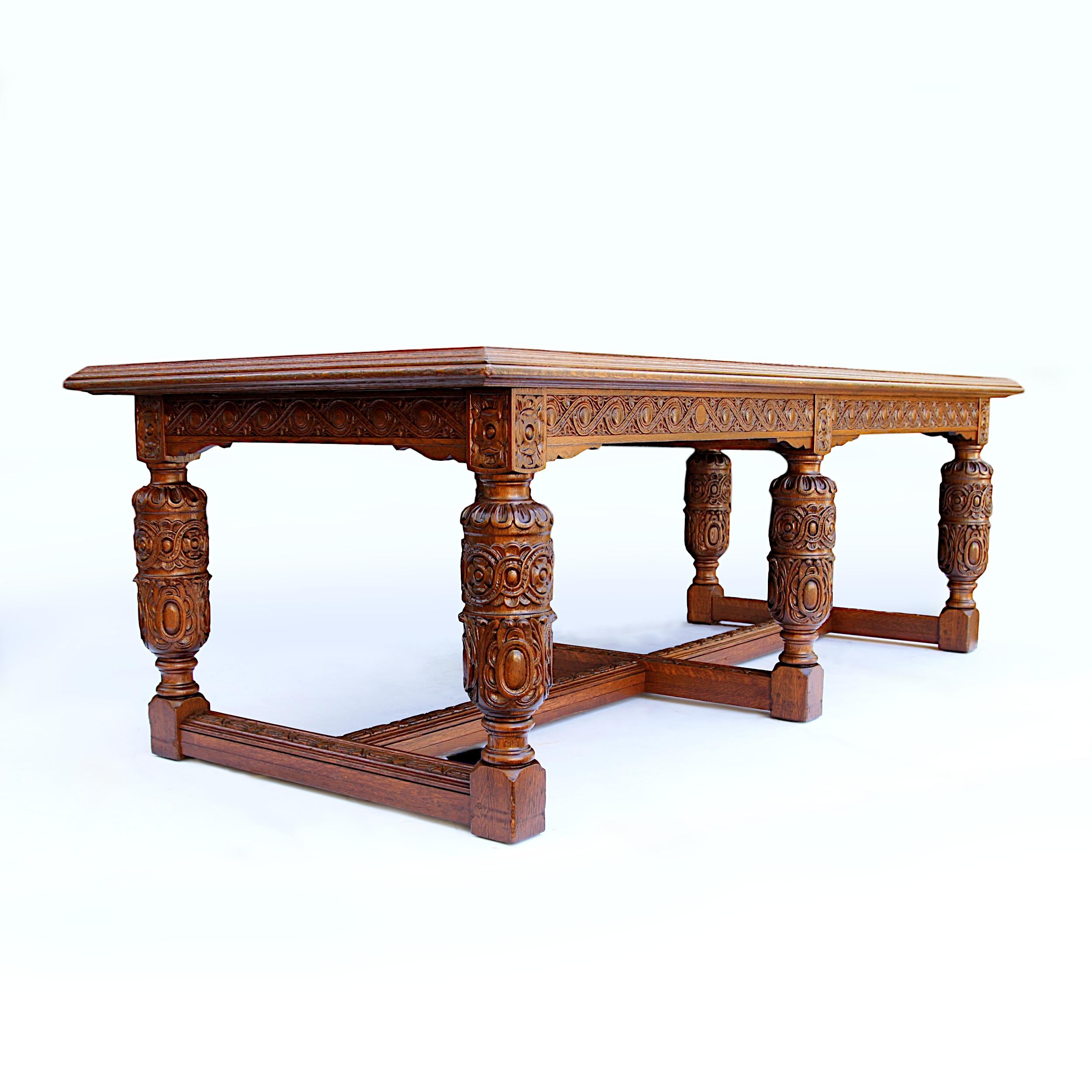 This monumental Jacobean Revival trestle table was custom made by the Romweber Furniture Co in the late 1920s. Table features solid oak construction, huge, 8ft long veneer top and ornate, high-relief carving throughout. This table was custom ordered
