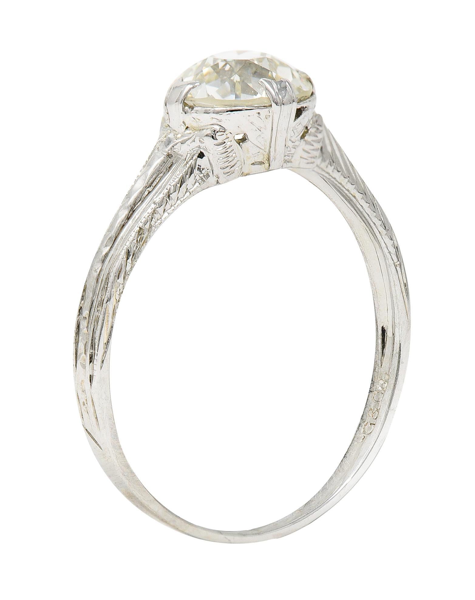 Featuring an old European cut diamond weighing approximately 1.60 carats - J color with SI2 clarity. Set by wide split prongs and resting in an intricately engraved head. Completed by engraved and faceted shoulders. Stamped 18K for 18 karat gold.