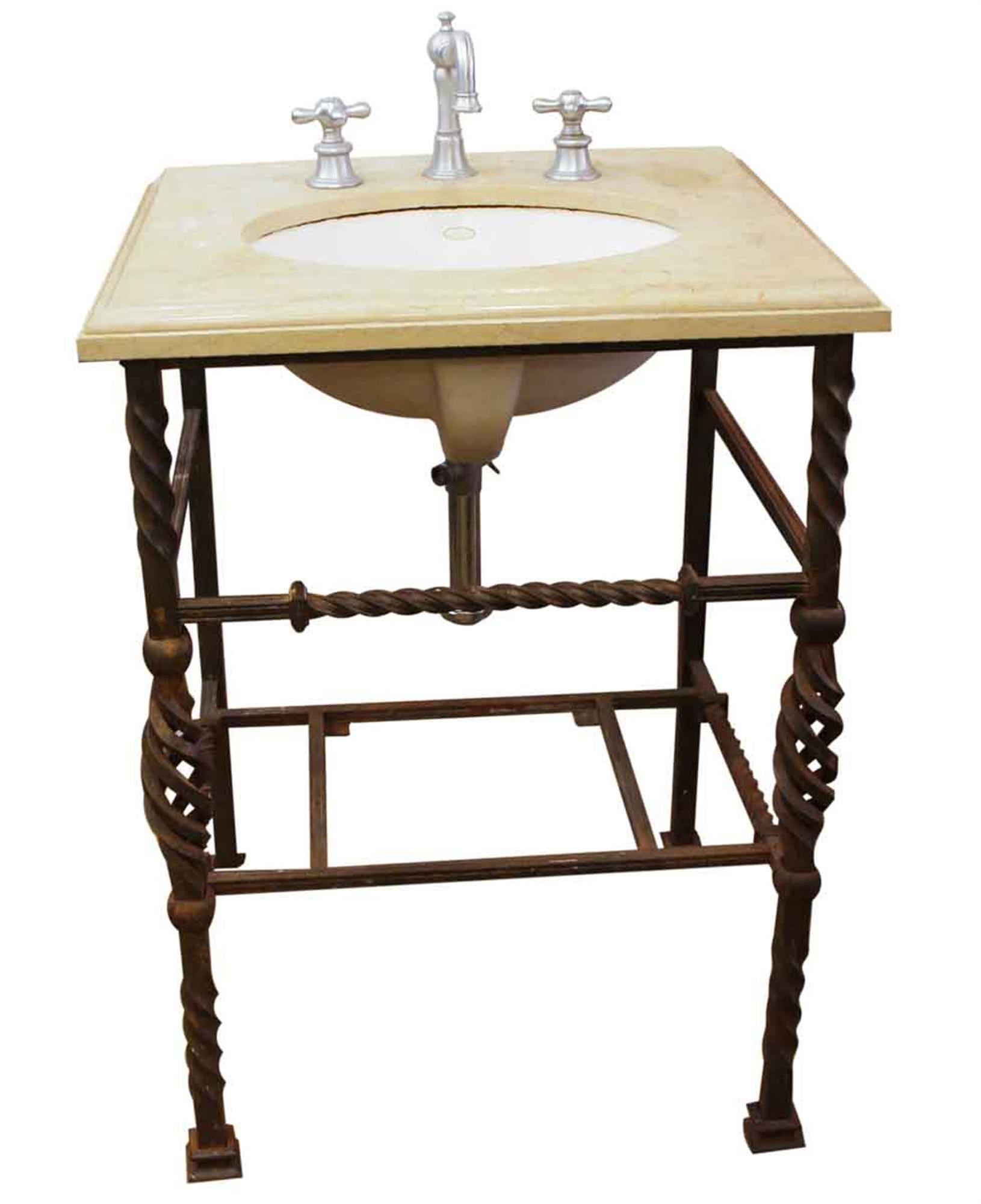 Tan colored Kohler marble sink with a decorative twisted wrought iron frame from the 1920s. The frame has some minor rust. The Kohler sink is newer but the hand wrought base is old. This can be seen at our 2420 Broadway location on the upper west