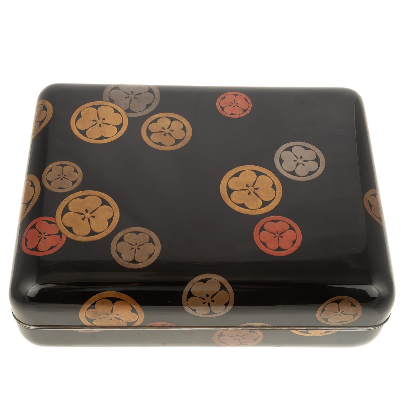 Gran caja japonesa de laca Maki-E de los años 20 con mon del shogunato Tokugawa.
Alrededor de 1920, exterior negro con varios mon colores mezclados del Shogunato Tokugawa, borde de metal plateado en la tapa y los bordes de la caja, interior decorado