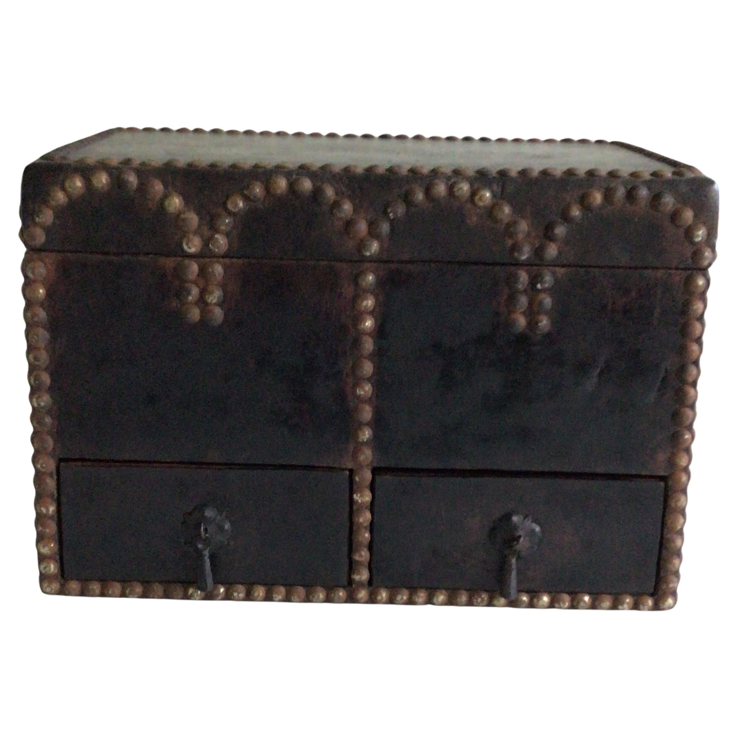 Caja de los años 20 forrada de cuero con tachuelas metálicas con cajones y tapa abatible