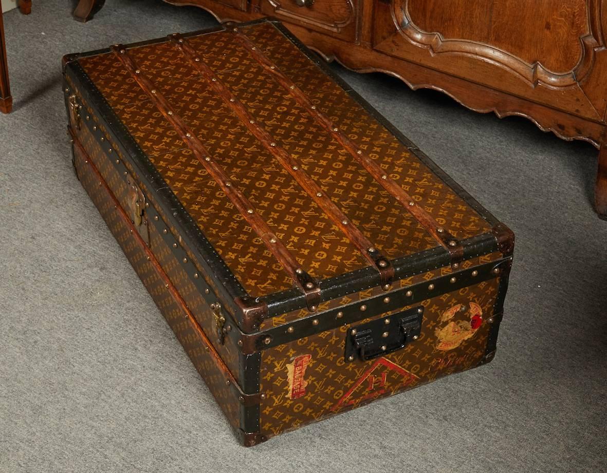 1920s Louis Vuitton cabin trunk with studded black metal trim and all inscribed L.V. with surface fitted by wooden trusts.