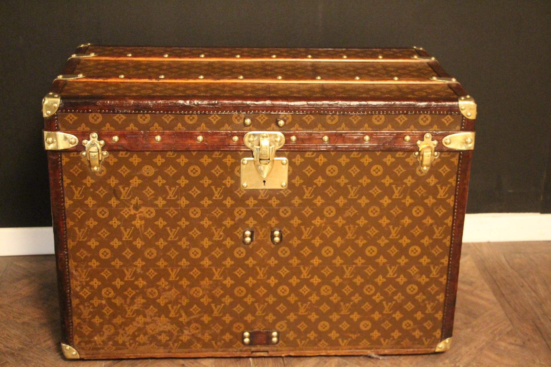 Superb Louis Vuitton steamer trunk featuring stenciled canvas, all leather trim in deep chocolate color, solid brass Louis Vuitton stamped clasps, lock and studs, solid brass corners and solid brass LV stamped side handles. Measure: 75