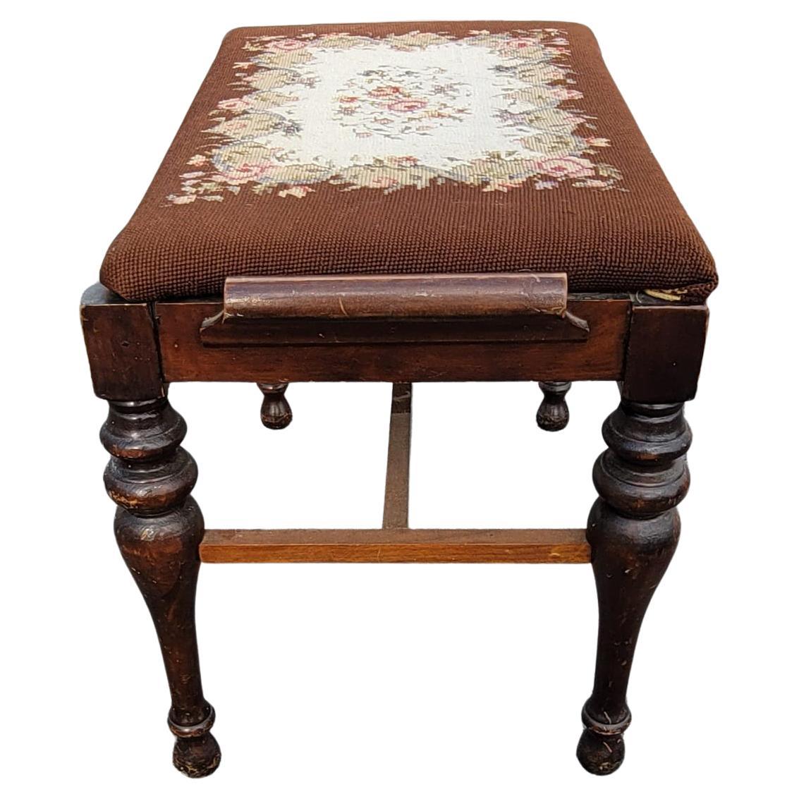 A charming and patinated George III style mahogany and needlepoint upholstered bench.