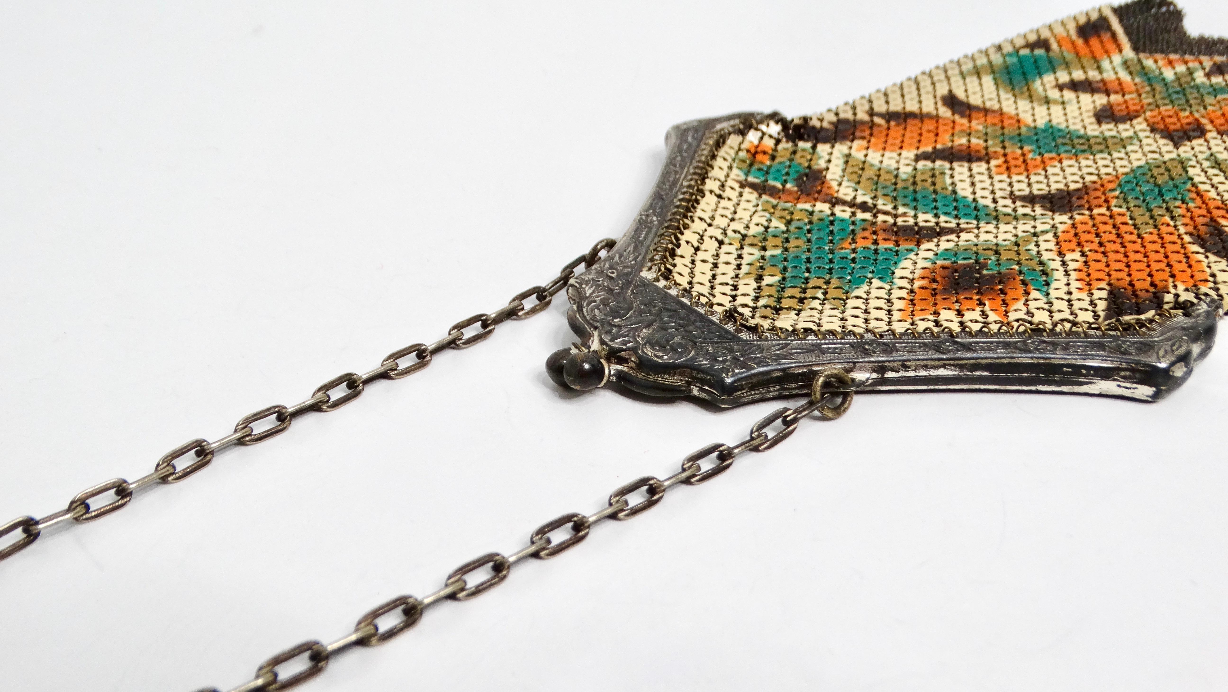 Step back into the roaring twenties with this exquisite Mandalian enameled mesh bag. A tan backdrop serves as a canvas for a vibrant floral display, featuring hues of orange, turquoise, and gold. The intricate enamel work captures the spirit of Art